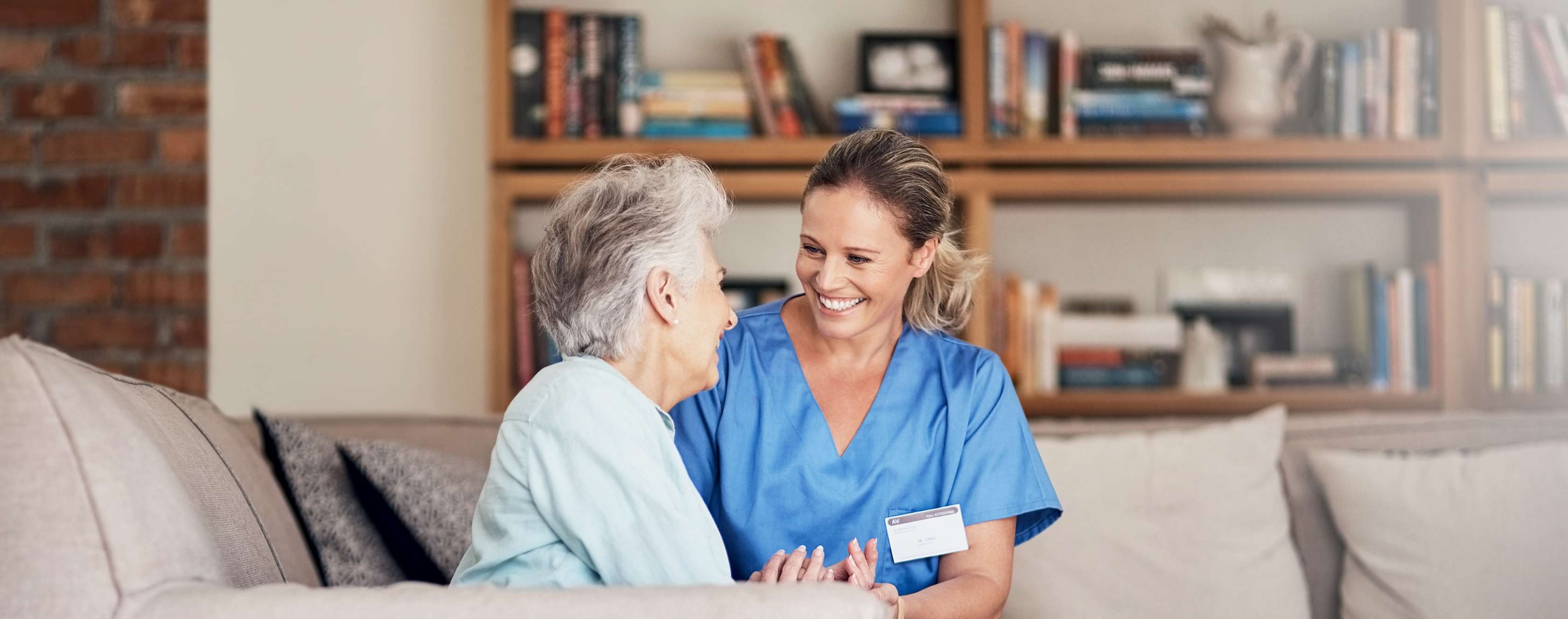 Pflegerin und ältere Frau lachen zusammen