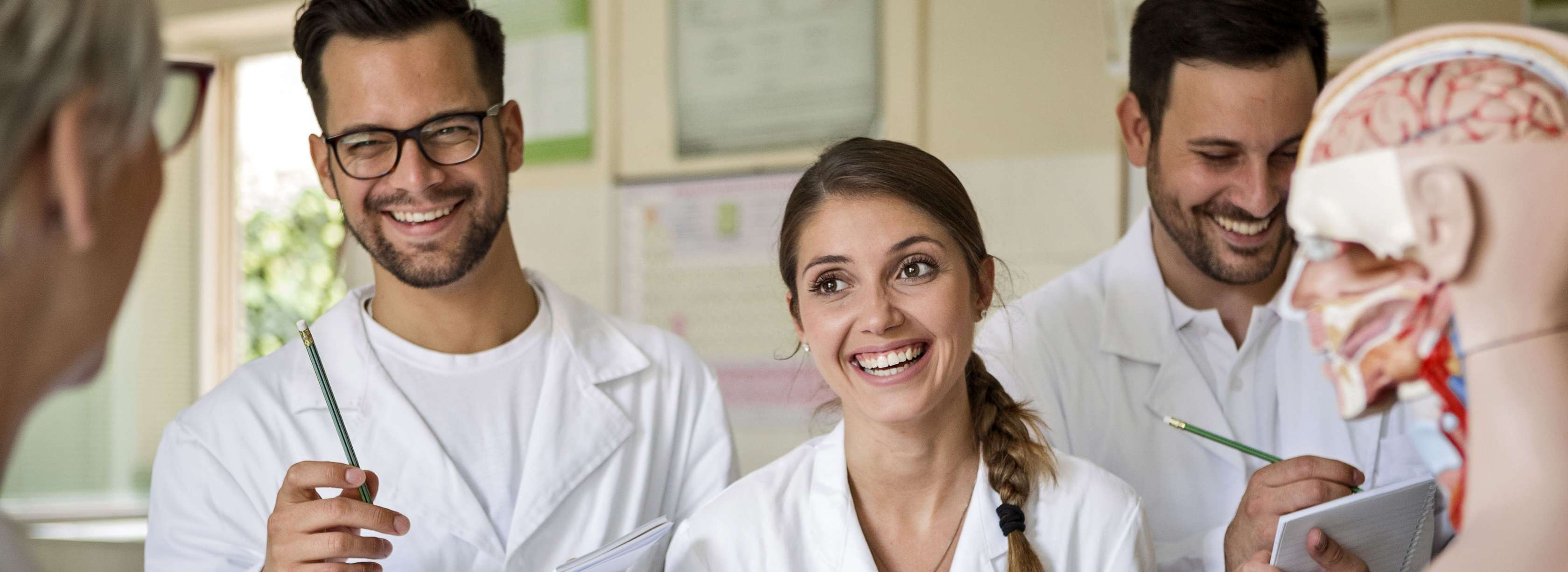Allianz Private Krankenversicherung für Ärzte: Arzt mit Akte in der Hand lacht mit Patientin 
