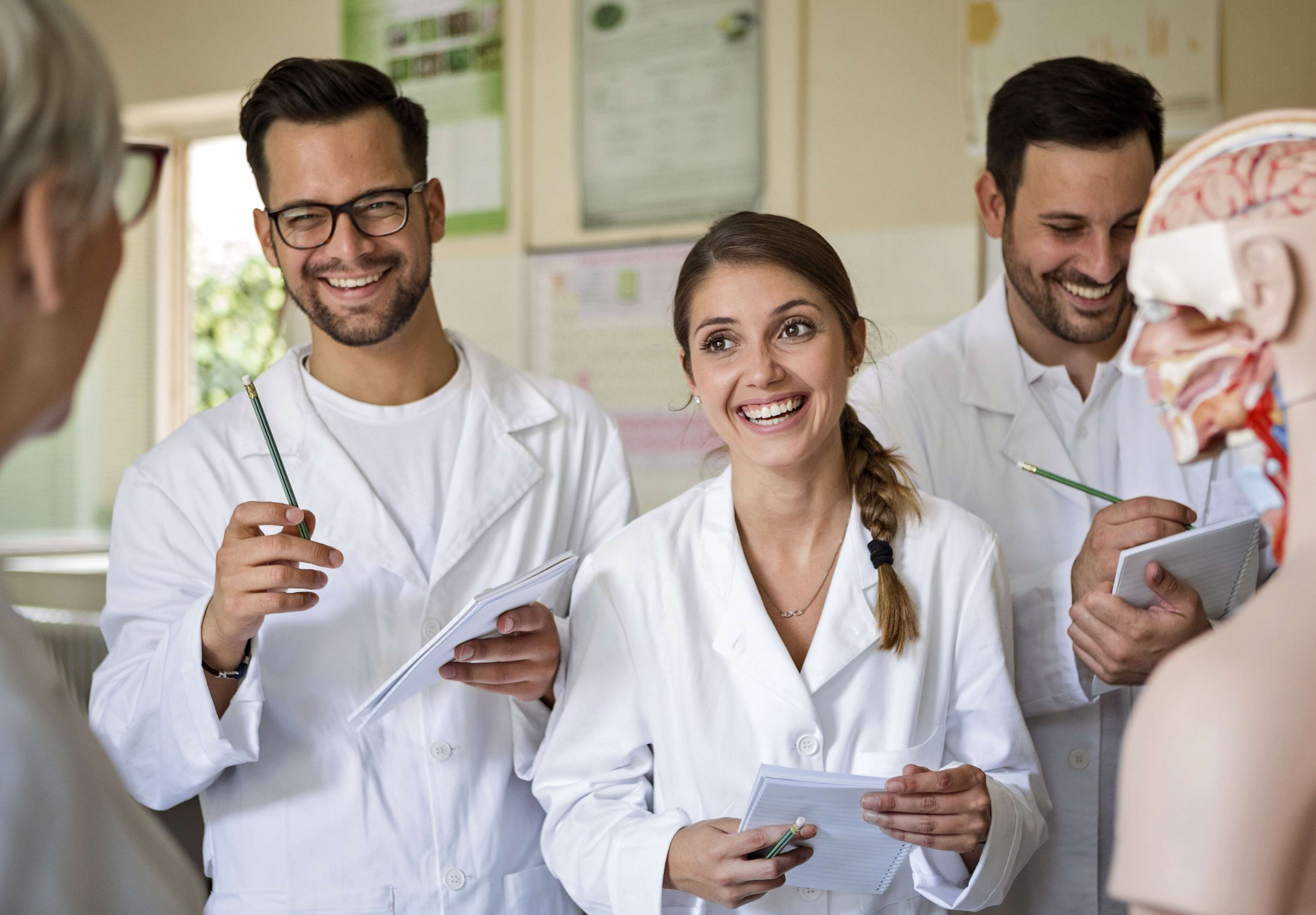 Allianz Private Krankenversicherung für Ärzte: Arzt mit Akte in der Hand lacht mit Patientin 