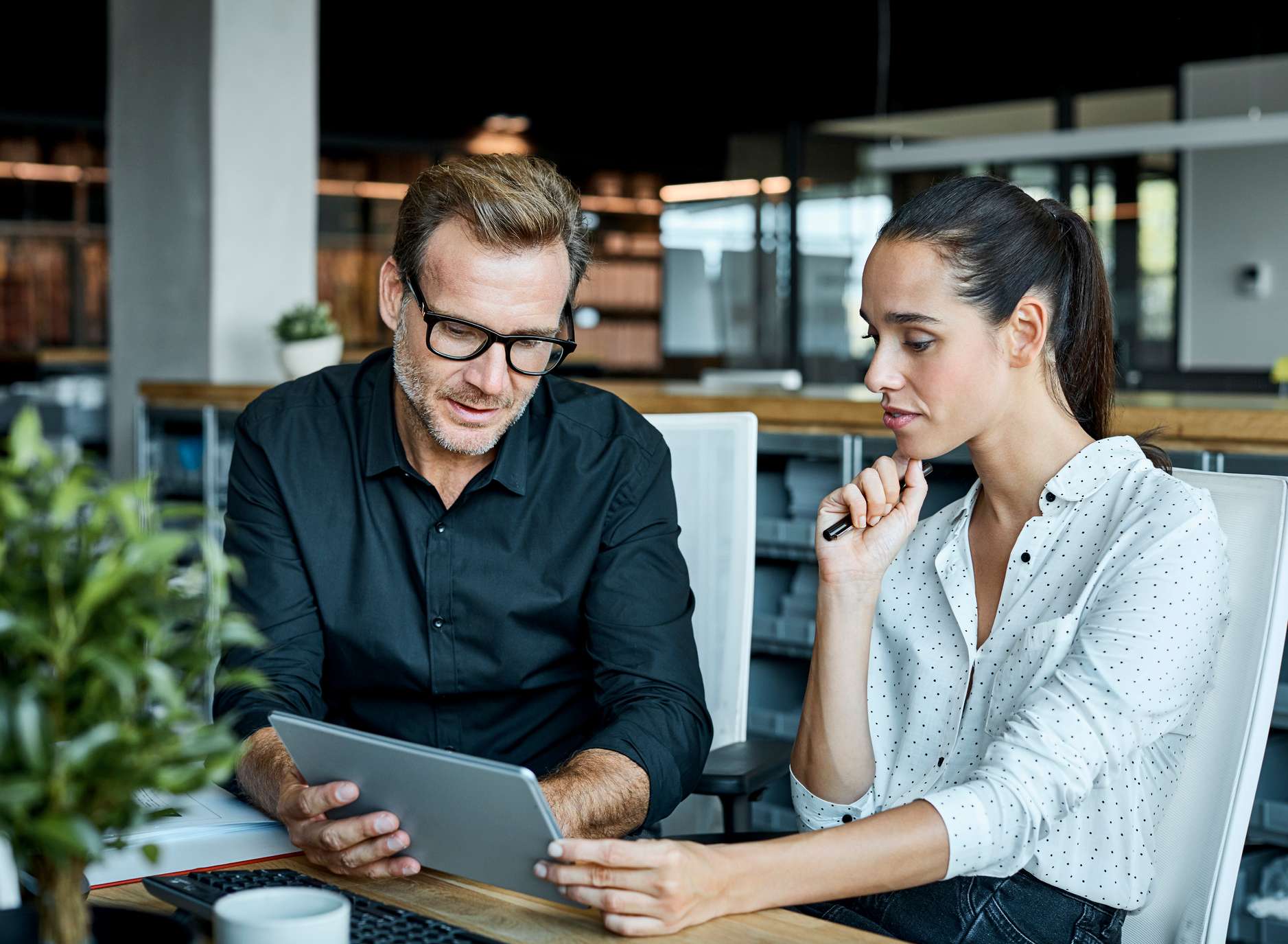 Allianz Arbeitgeberzuschuss in der Privaten Krankenversicherung. Ein Mann und eine Frau sitzen am Tisch uns besprechen etwas.