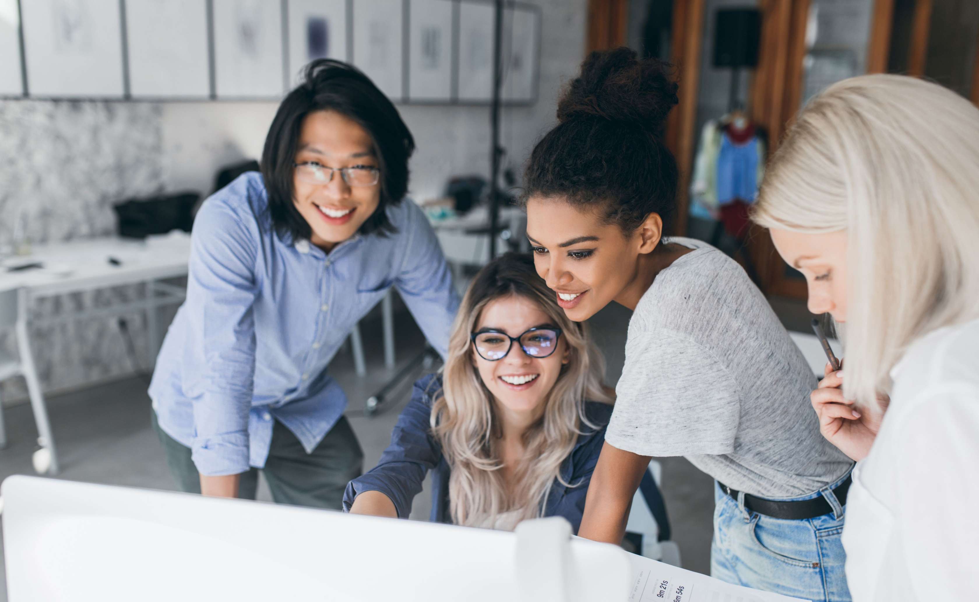 Allianz Private Krankenversicherung für Ausländer:innen: Eine Gruppe von Frauen steht vor einem Computer und unterhält sich. 