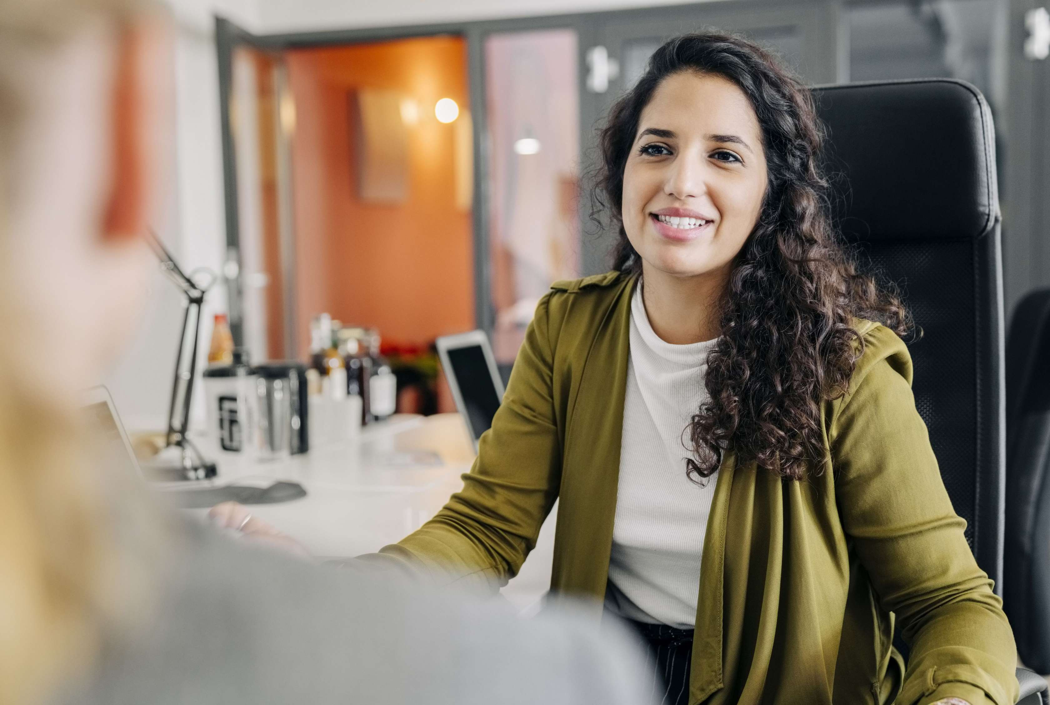 Allianz Private Krankenversicherung für Beamte und Beamtinnen: Eine Frau sitzt jemandem gegenüber und unterhält sich über Tarife.