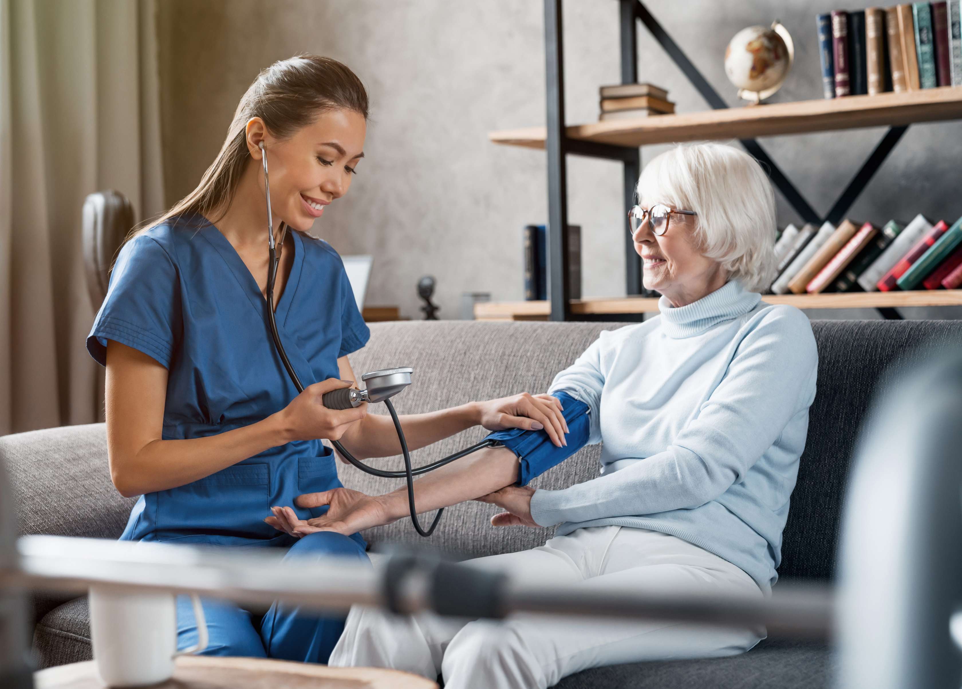 Allianz Behandlungspflege in der Privaten Krankenversicherung: Ihre Vorsorge im Krankheitsfall zu Hause. Eine Pflegerin untersucht eine alte Dame.