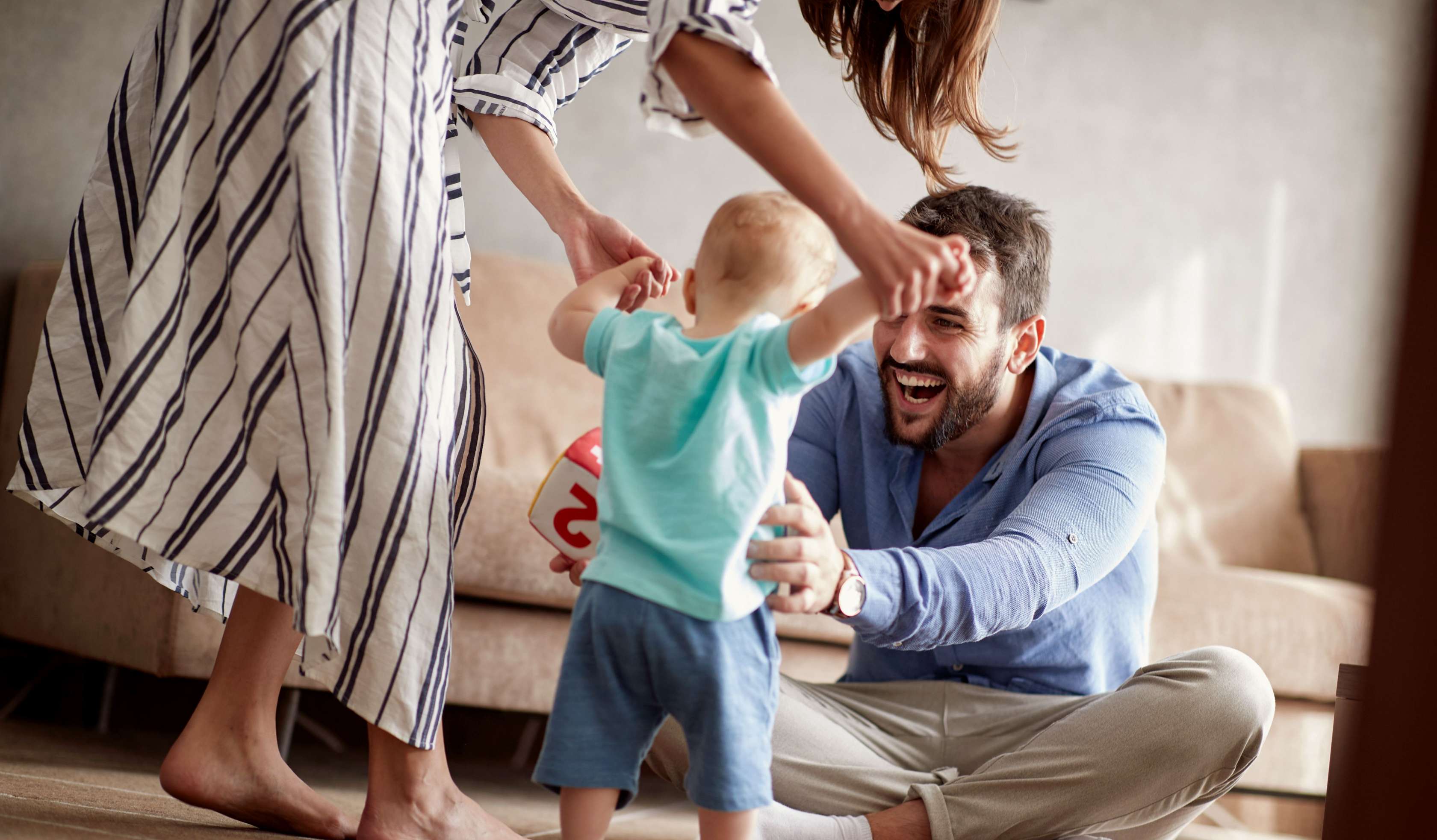 Allianz Private Kranken­versicherung in der Eltern­zeit: Beitrag über die private Krankenversicherung während der Elternzeit, einschließlich Besonderheiten und weiterer Informationen. Eine junge Familie spielt mit ihrem kleinen Sohn. 