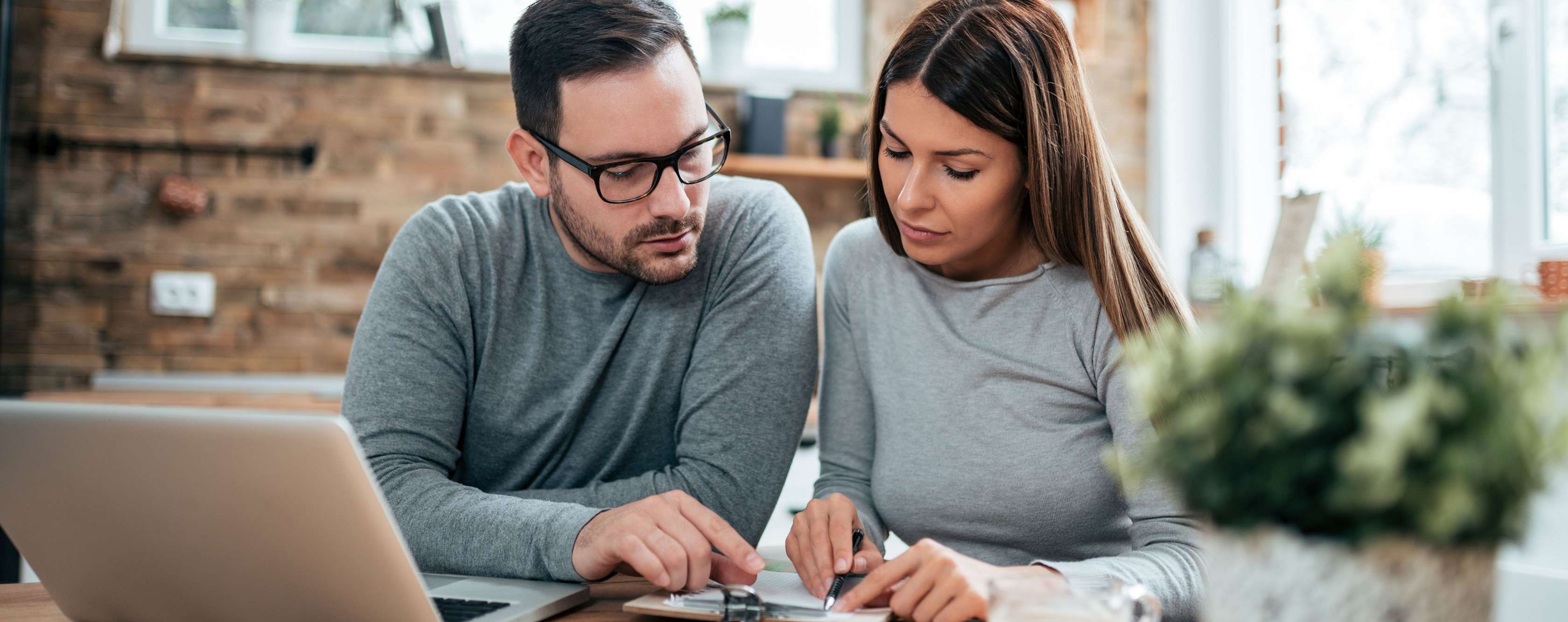 Allianz Risikoeinschätzung der PKV: Warum die Gesundheitsprüfung in der privaten Krankenversicherung notwendig ist. Ein Paar sitzt am Tisch und vergleicht Tarife.