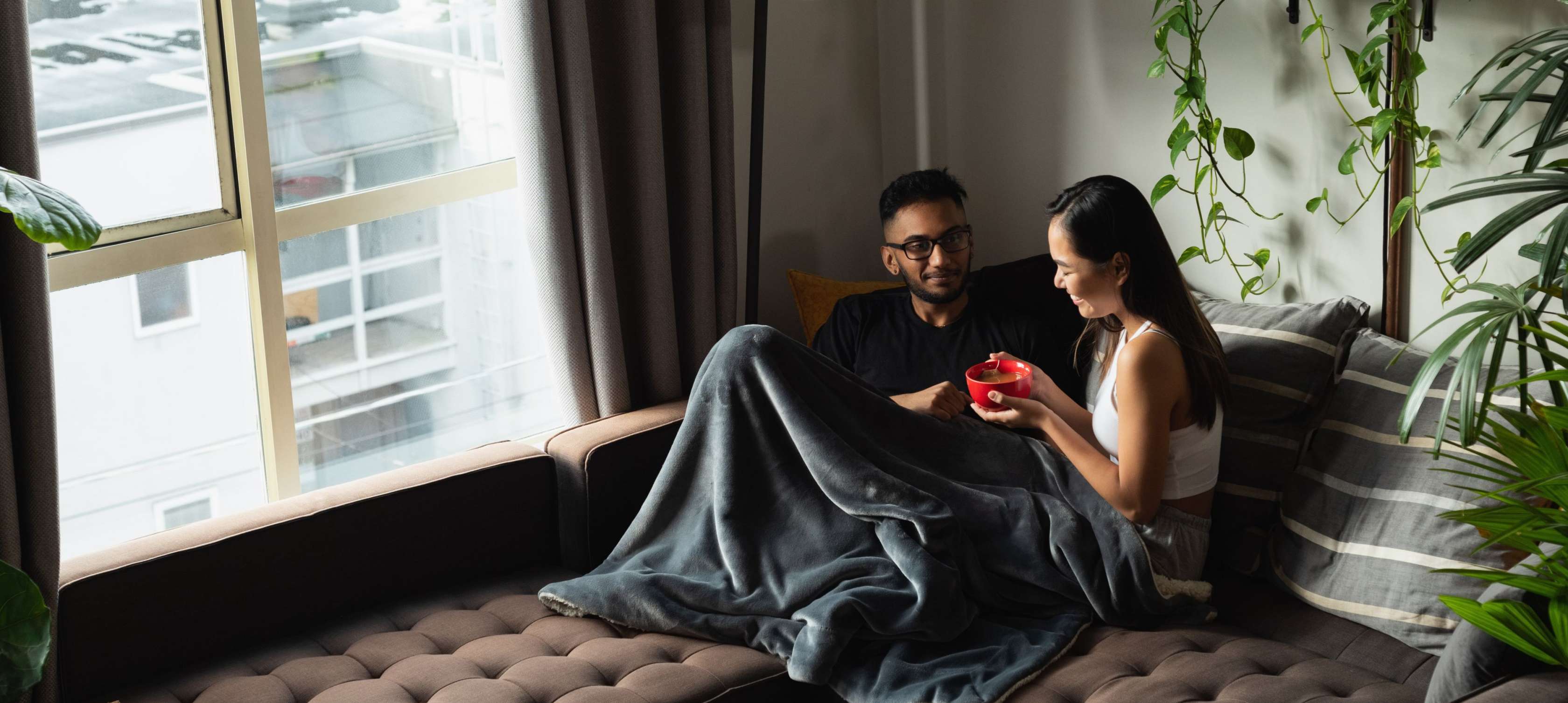 Allianz Private Krankenversicherung - So kommen Sie gut durch die Grippezeit: Mythen und Irrtümer über Grippe aufgedeckt. Ein Paar sitzt auf einem Sofa und unterhält sich.