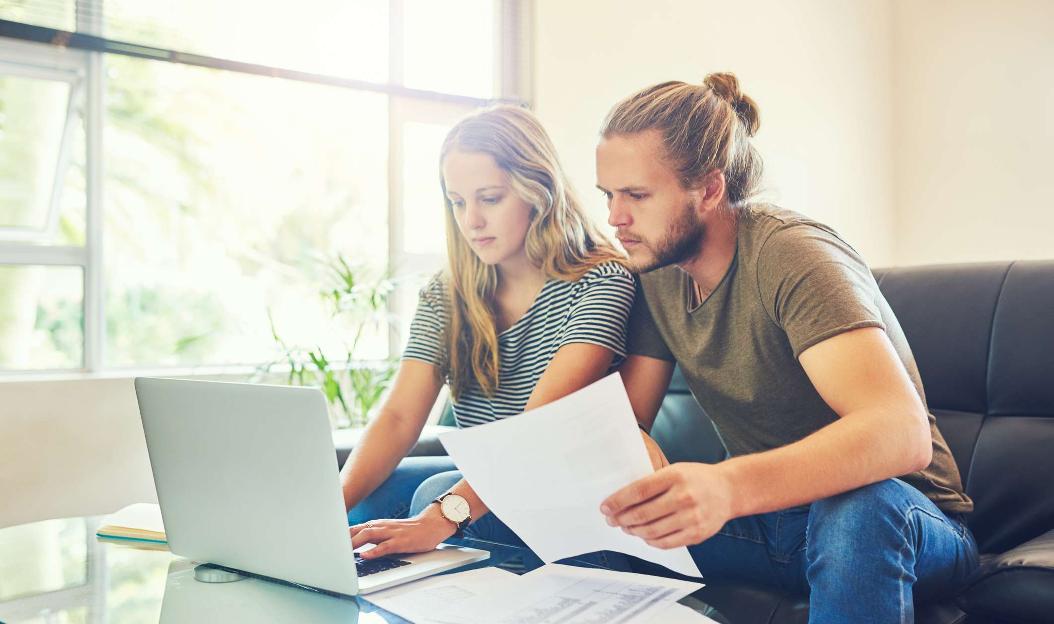 Allianz private Krankenversicherung Kostenübernahme. Das sollten Sie wissen über die Kostenübernahme in der privaten Krankenversicherung. Ein junges Paar sitzt am PC und vergleicht Dokumente.
