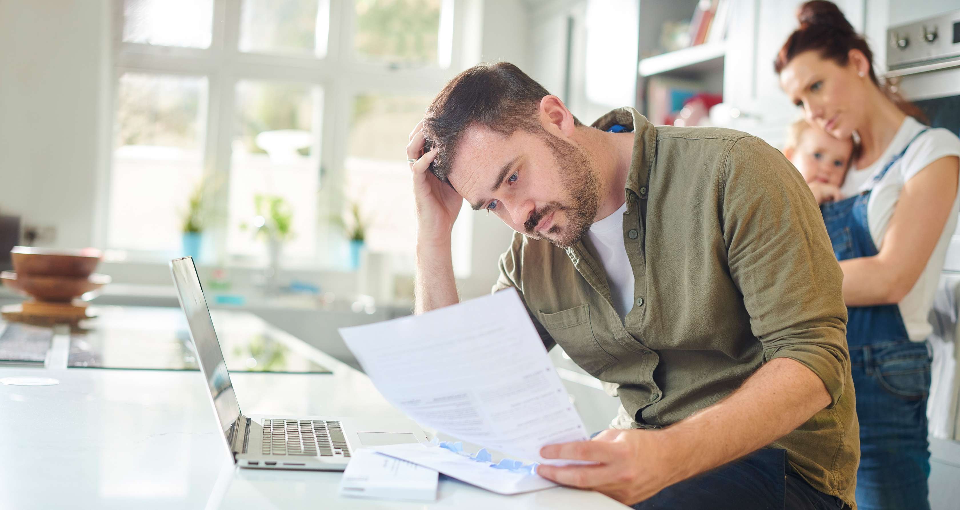 Allianz Krankenversicherung nach Kündigung: Wissenswertes für Arbeitnehmer und Arbeitnehmerinnen. Ein Mann sitzt nachdenklich über einem Dokument.