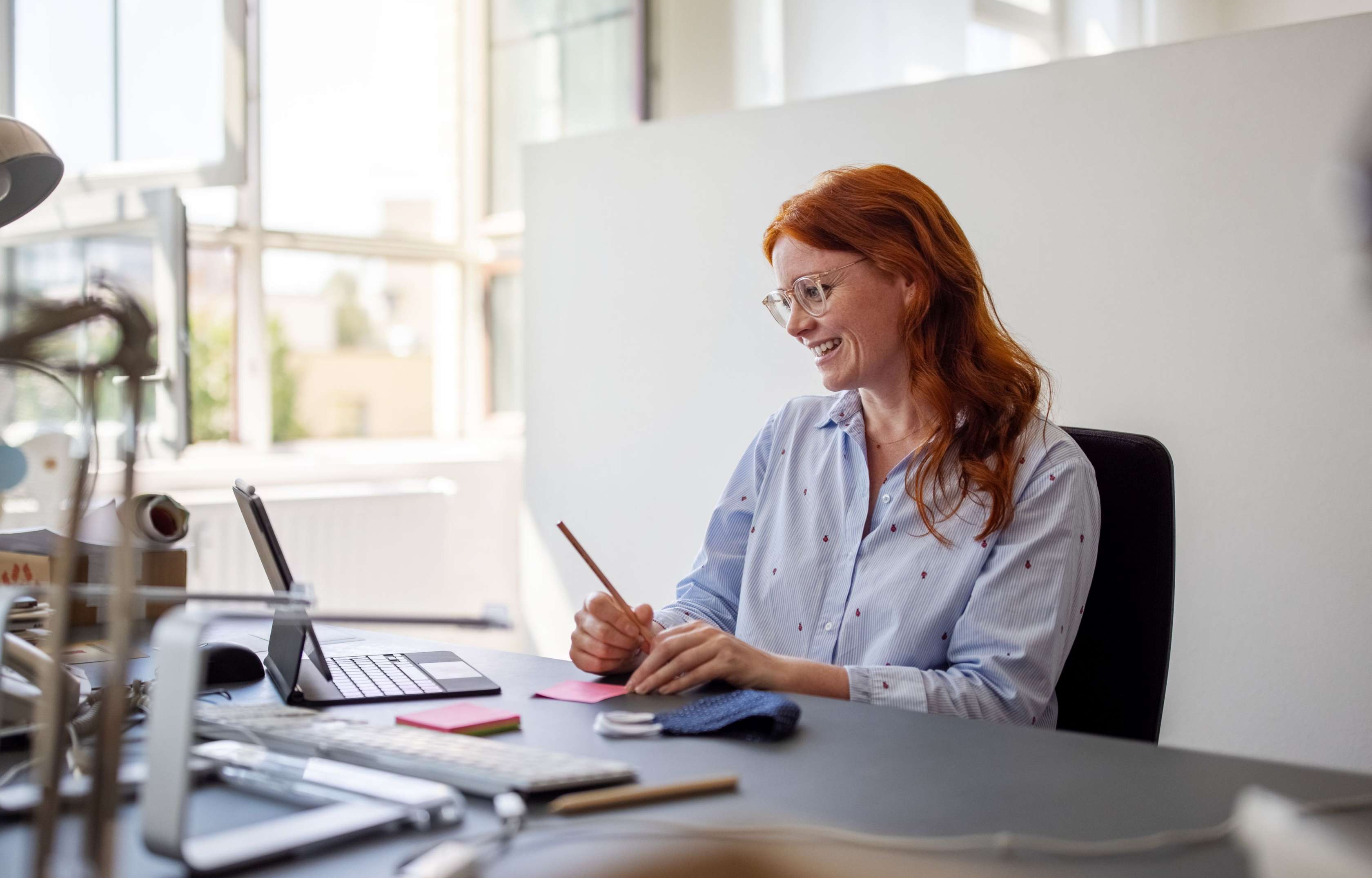 Allianz Private Krankenversicherung und Minijob: Rechtlicher Rahmen, Kosten, Leistungen. Eine junge Frau sitzt am PC und notiert sich etwas auf einem Zettel.