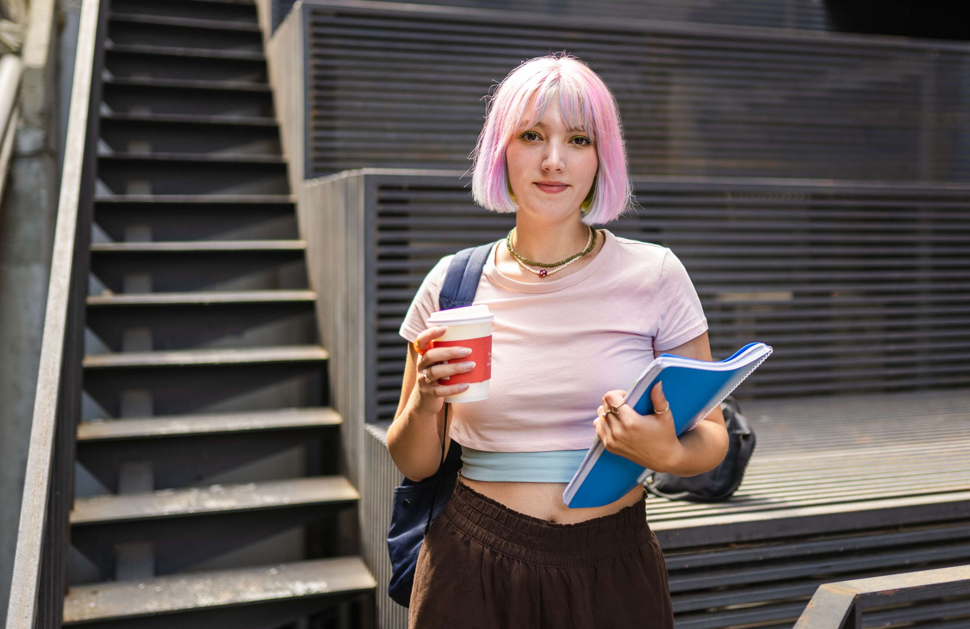 Allianz Optionstarif OptiFlexiMed die Eintrittskarte für die private Krankenversicherung. Eine Studentin steht vor einer Treppe und blickt in die Kamera.