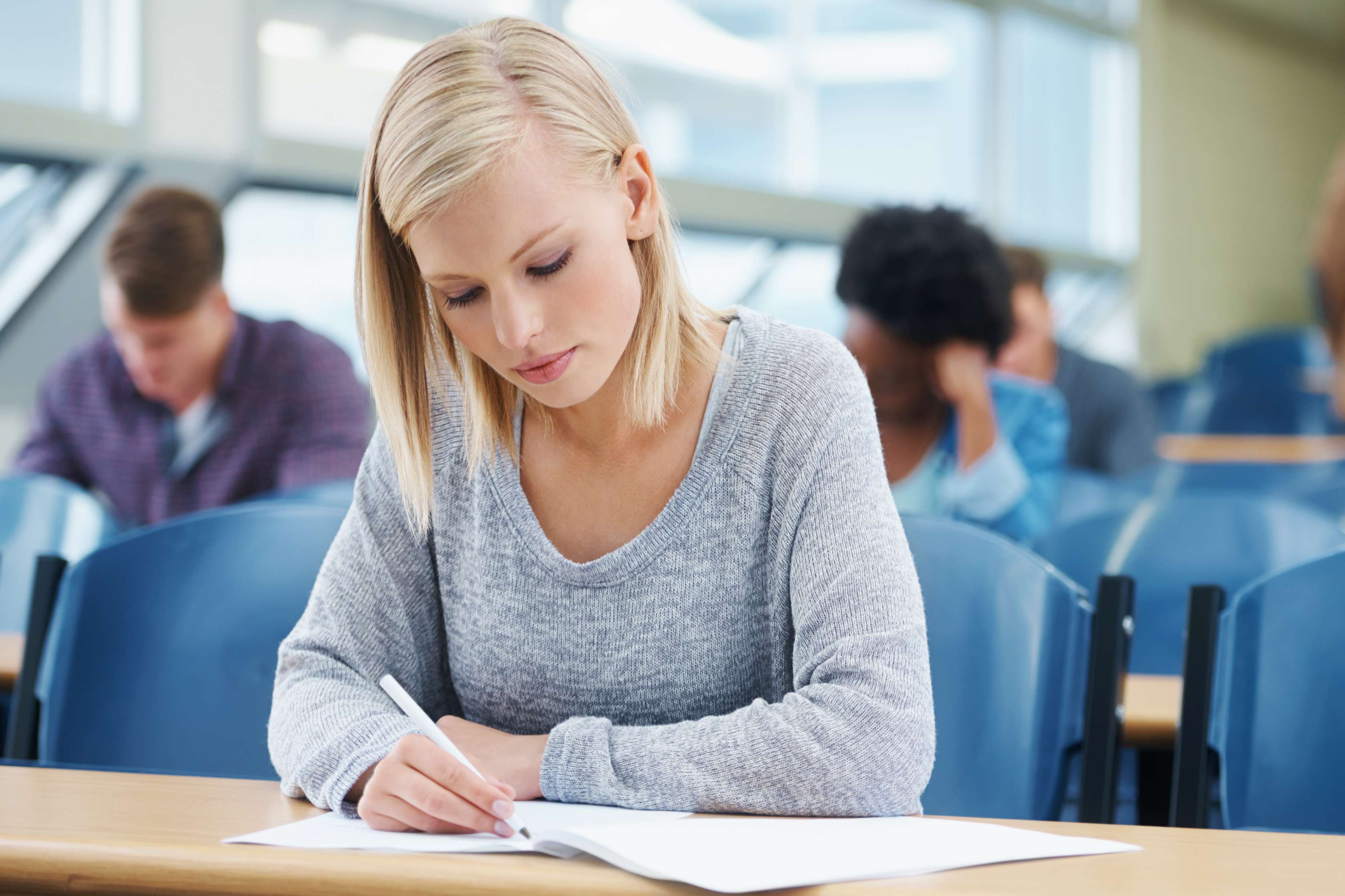 Die Seite erläutert alles Wissenswerte zu den Studententarifen der Allianz Private Krankenversicherung für Studenten und Studentinnen. Das Bild zeigt eine Studentin im Hörsaal, die gerade etwas notiert.
