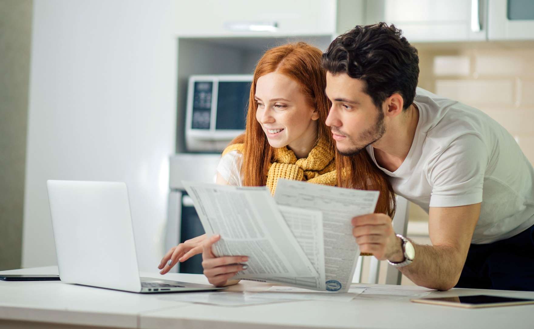 Allianz Zahnleistungen in der PKV: Eine Frau und ein Mann schauen sich gemeinsam Unterlagen an.