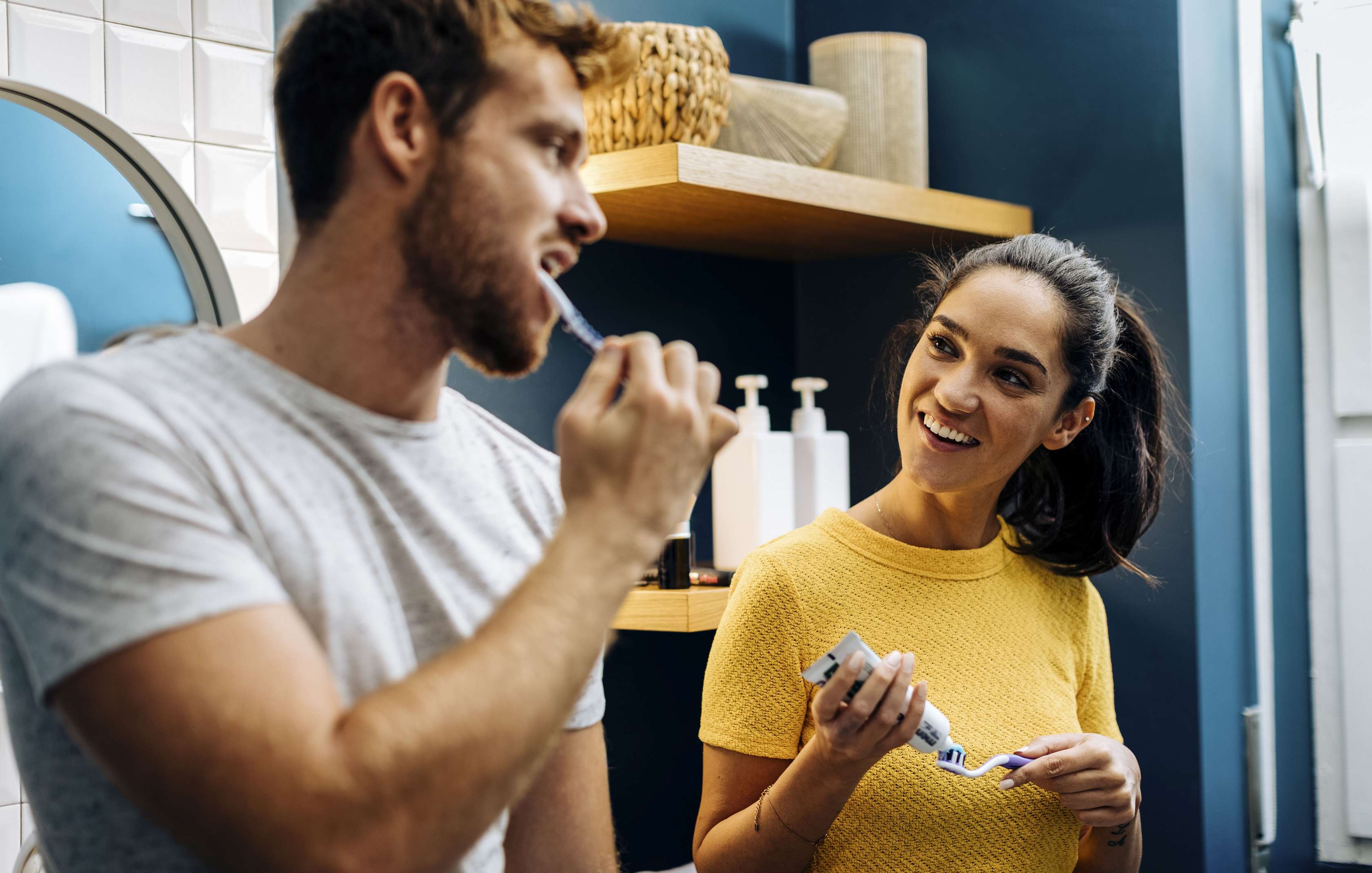Zahnzusatzversicherung fuer Privatversicherte: Ein junges Paar beim gemeinsamen Zähneputzen im Badezimmer. 