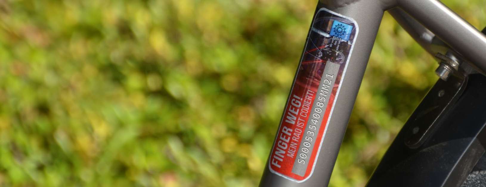 Nahaufnahme eines Fahrradrahmens mit Codierungsplakete. Zu lesen ist die Nummer und der Schriftzug "Finger weg!". 