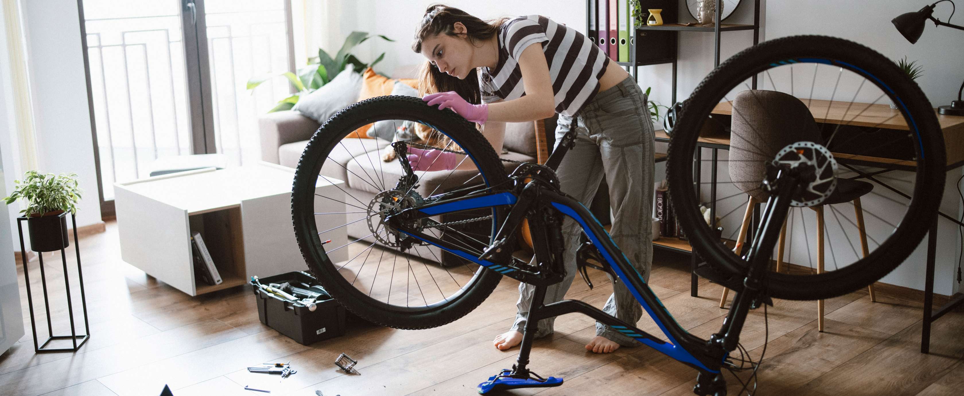 Gegenstandsschutz: Eine Frau pflegt ihr Fahrrad in ihrer Wohnung