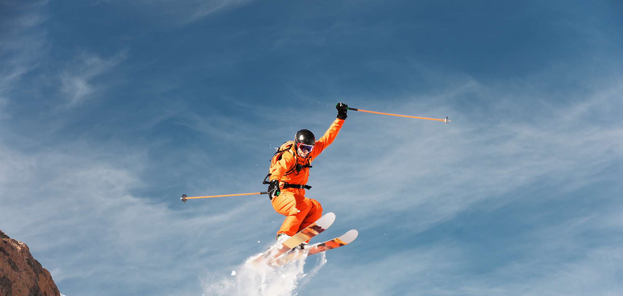 Skiversicherung: Person springt auf Skiern in die Luft