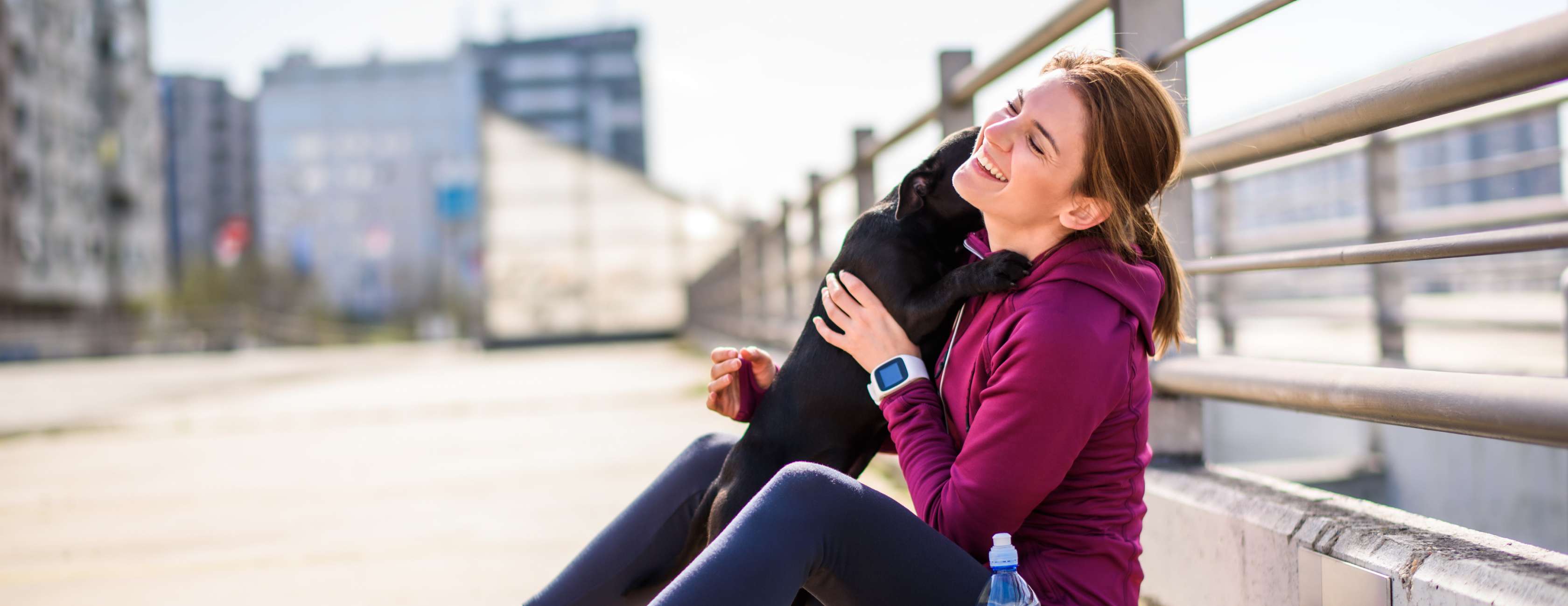 Allianz - Hunderassen für Anfänger: Sitzende Frau spielt mit ihrem Hund