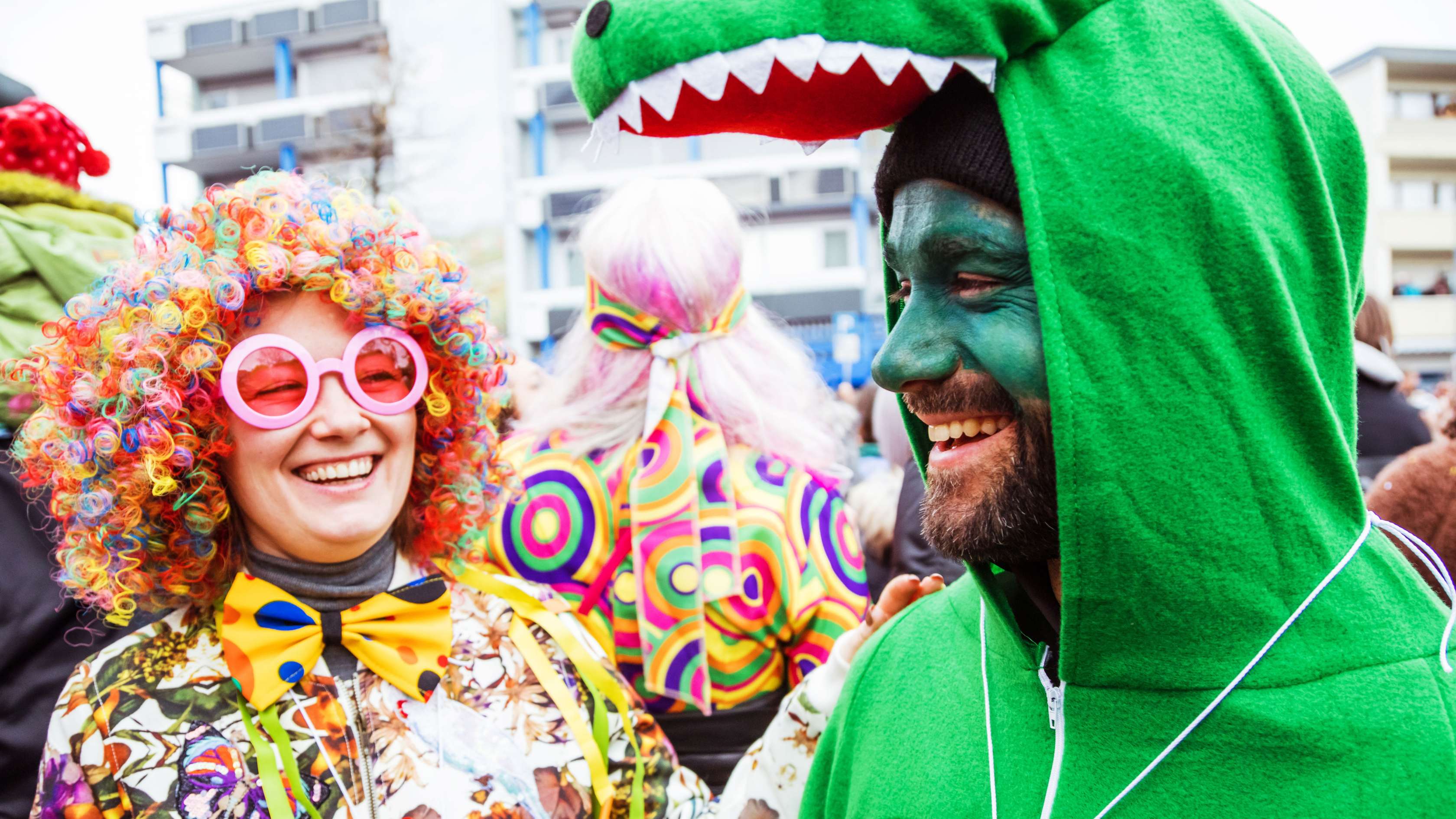 Karneval auf der Straße: Eine Mann im Krokodilkostüm und eine Frau als Clown verkleidet