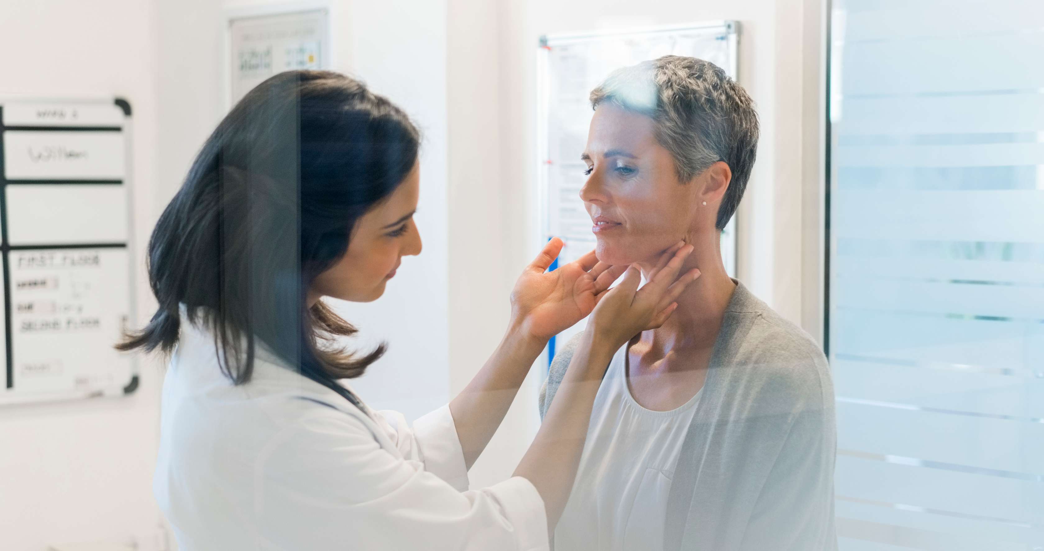 Arzttermin während der Arbeitszeit: Eine Ärztin überprüft den Hals einer Patientin