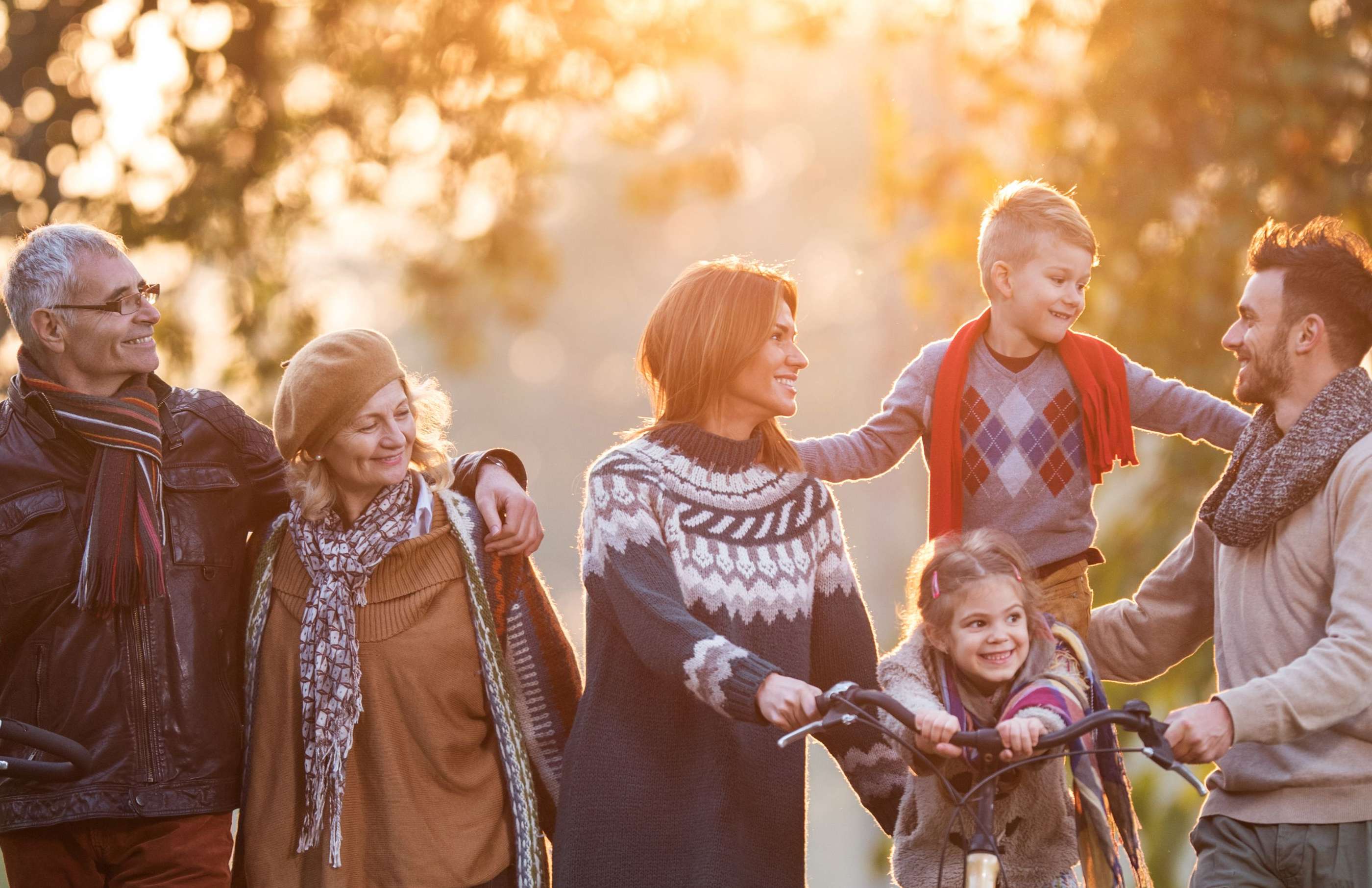 Allianz Familienrechtsschutzversicherung: Familie mit zwei Kindern geht im Wald mit Großeltern spazieren