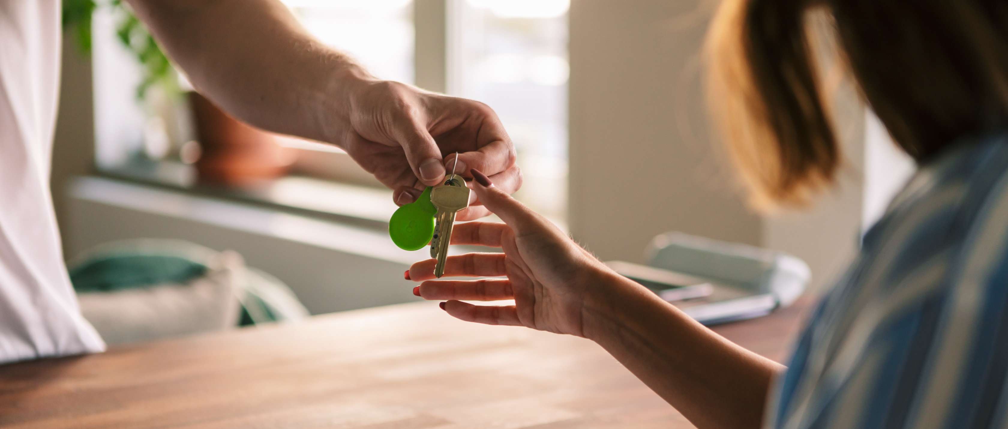 Mietrecht: Junge Frau bekommt einen Schlüssel überreicht