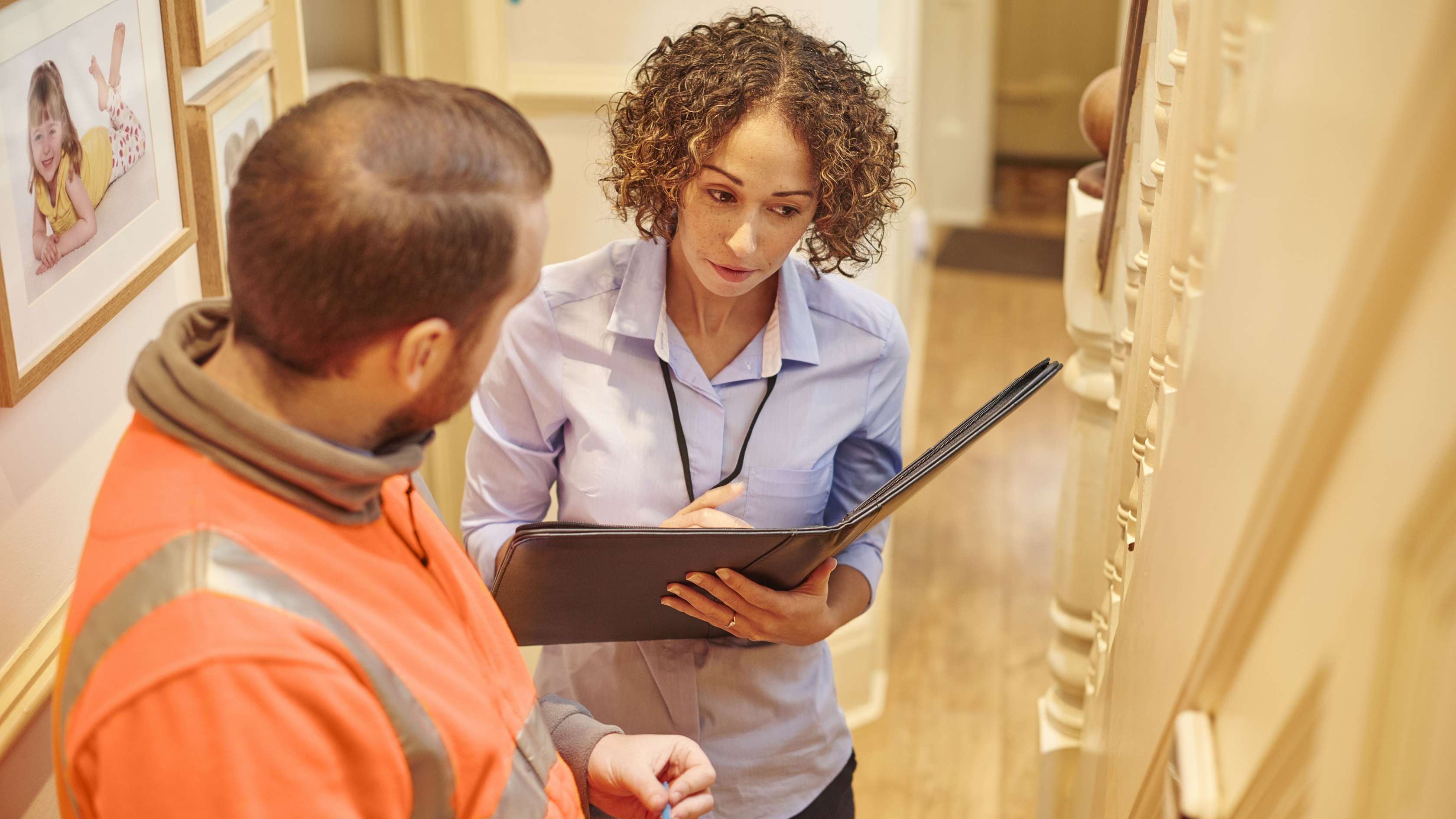Vermieter und Mieter stehen im Gespräch vor einer Wohnungstüre