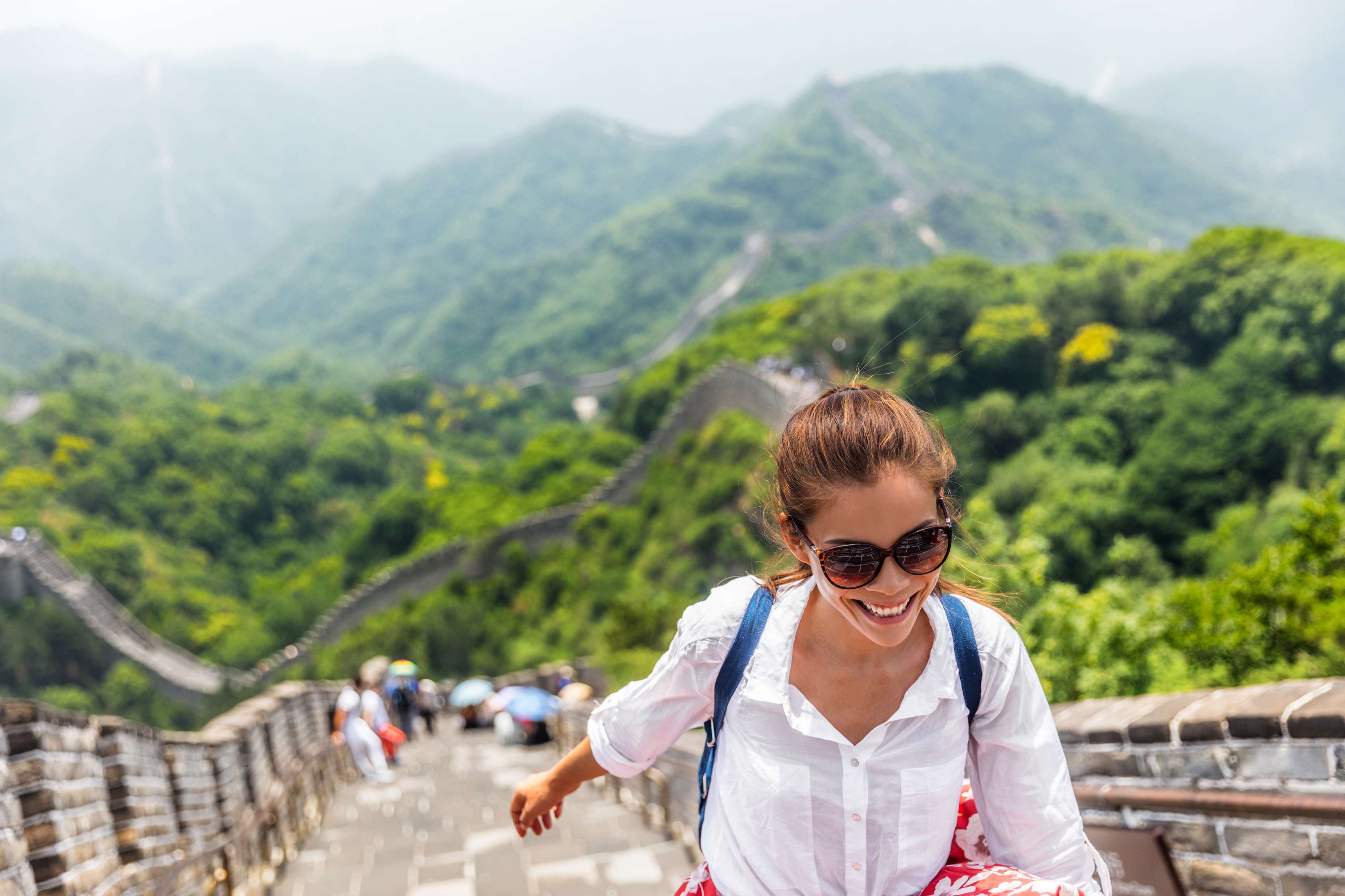 Junge Frau lacht und läuft auf Chinesischer Mauer
