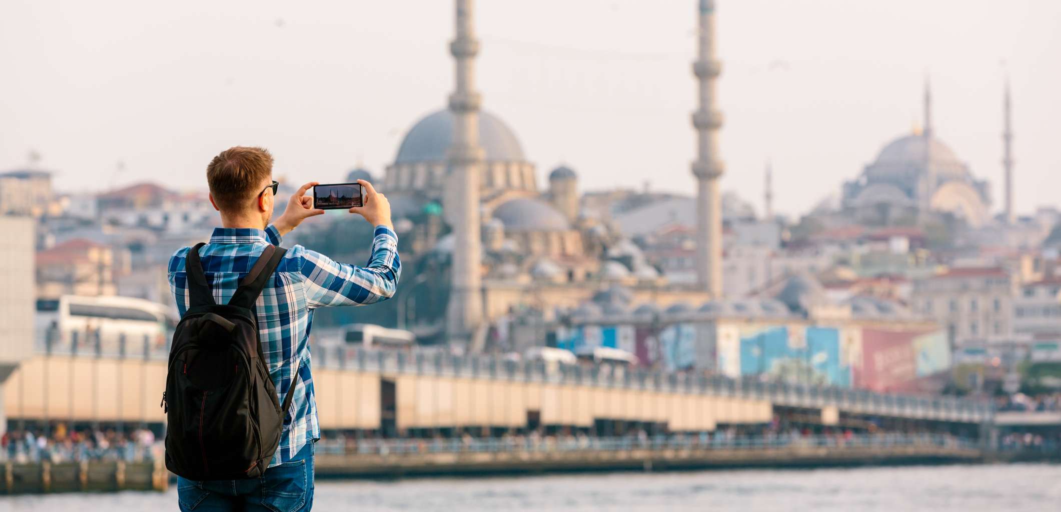 Junger Mann mit Rucksack macht ein Foto von der Istanbuler Skyline