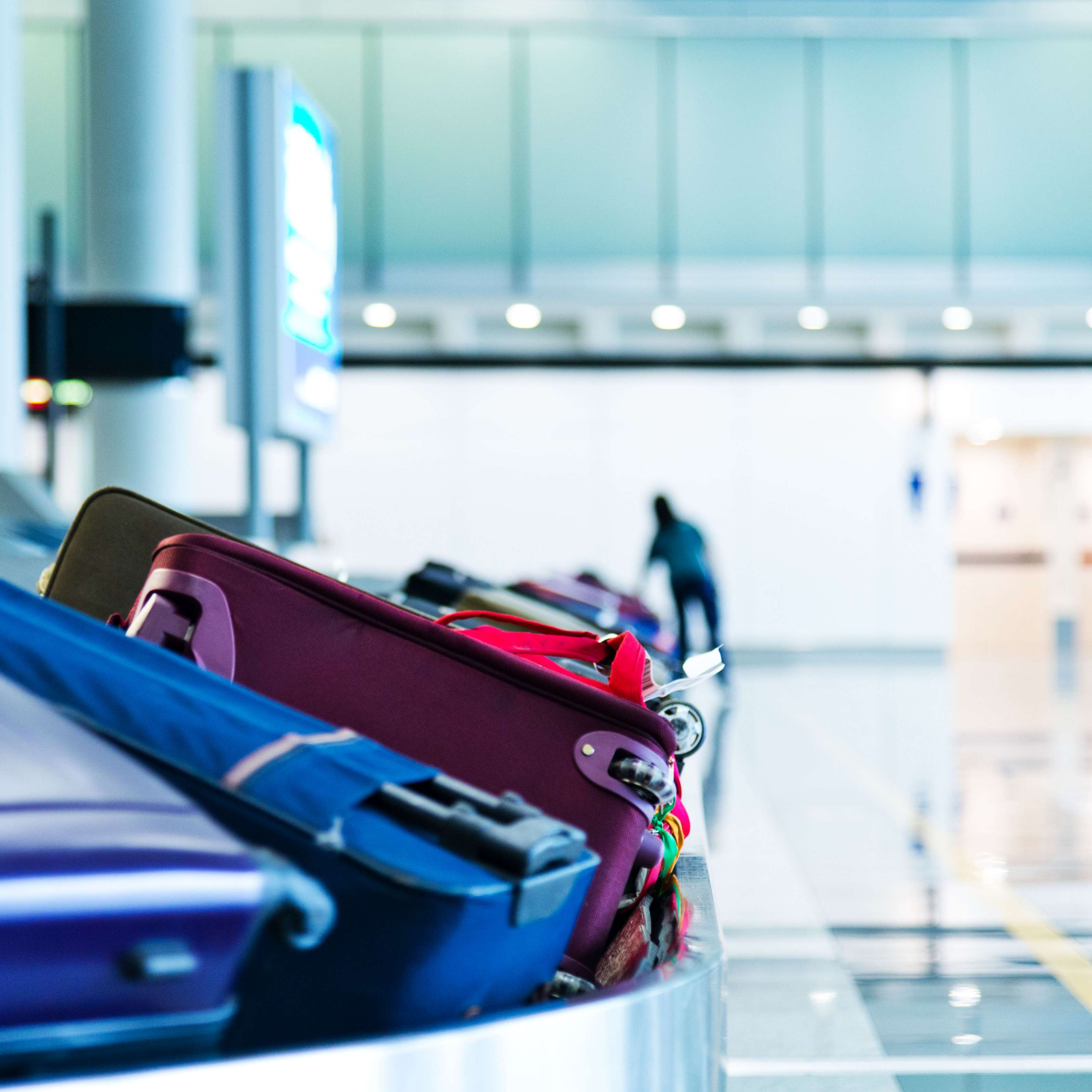 Allianz - Beschädigtes Reisegepäck: Koffer auf dem Gepäckband am Flughafen