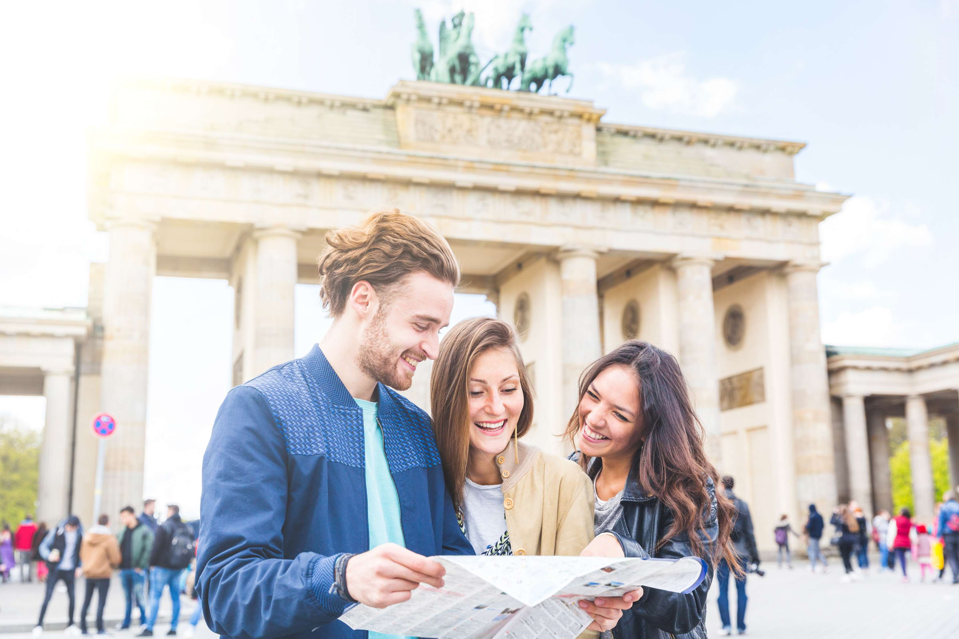 Allianz - Versicherung für Ausländer: Drei junge Menschen vor dem Brandenburger Tor