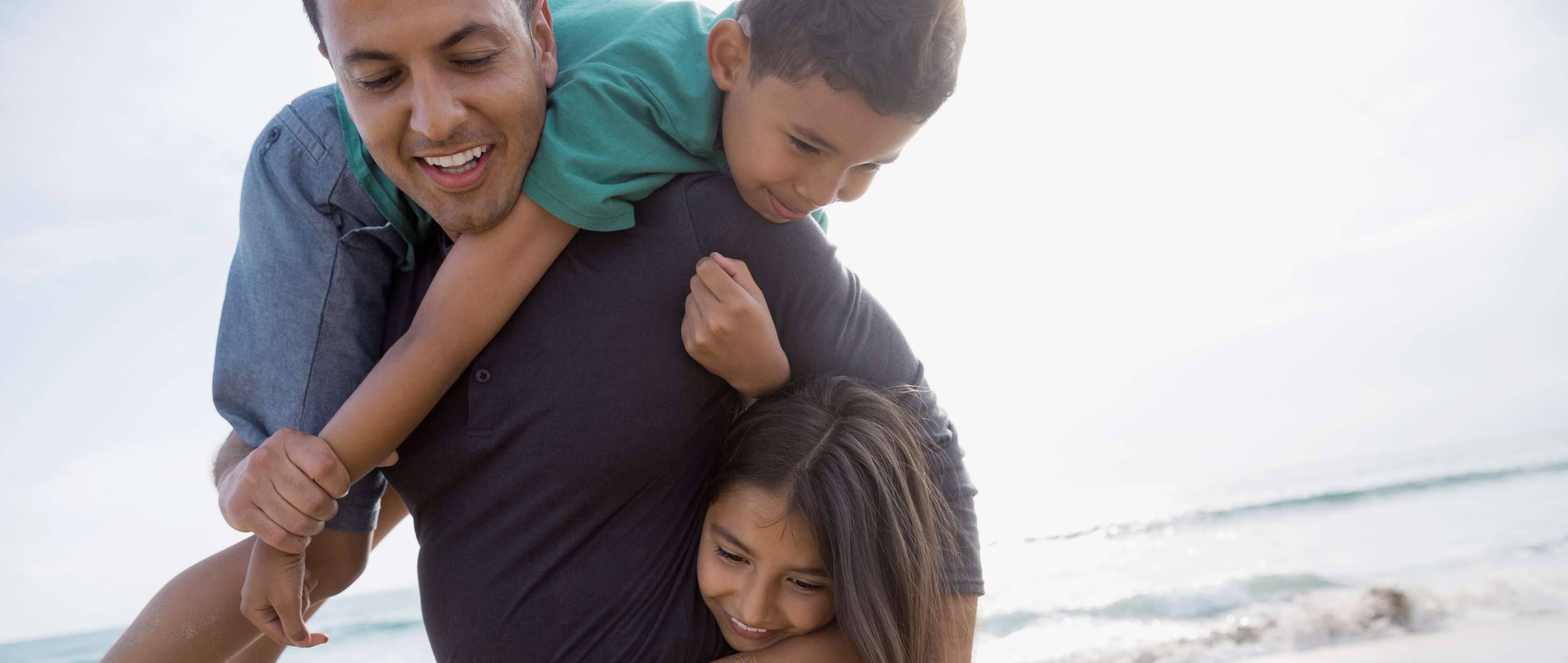 Allianz AllProtect: Mann spielt mit Kindern am Strand