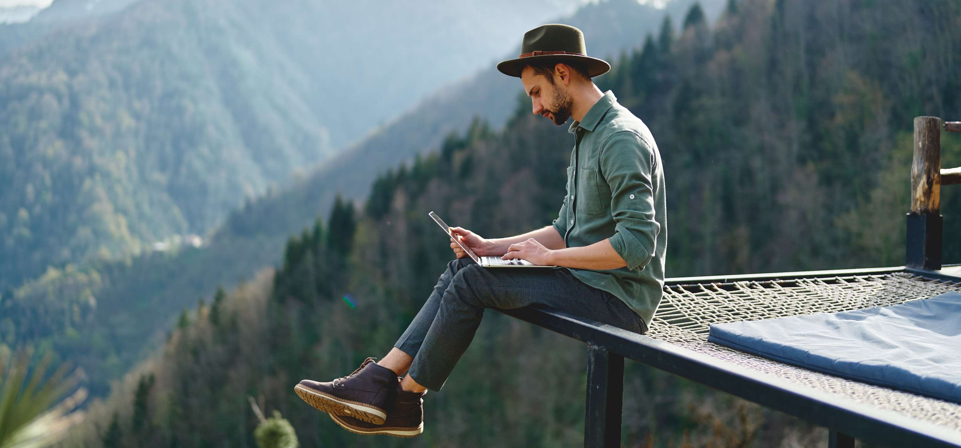 Meine Allianz: Ihr persönliches Kundenportal - Mann sitzt mit Laptop vor Bergkulisse
