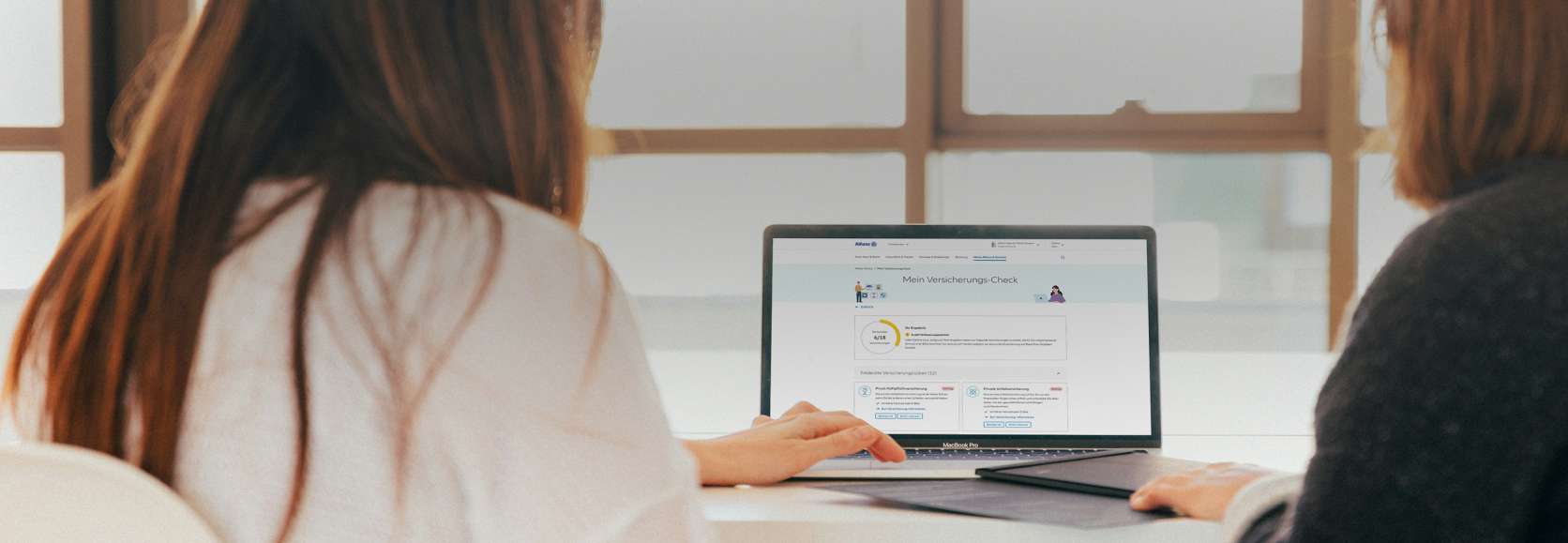 Allianz Versicherungs-Check: Zwei Frauen sitzen am Computer und bedienen den Versicherungs-Check der Allianz