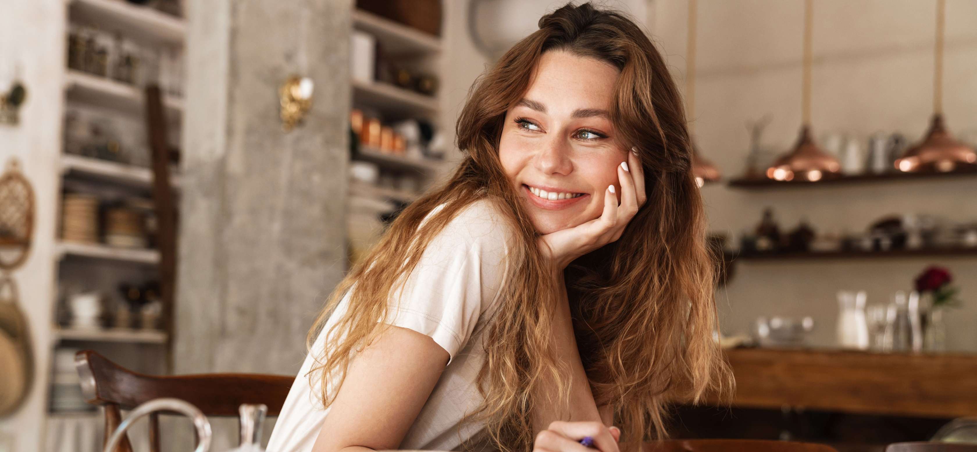 Allianz Vorteilsprogramm - Punkte einlösen und attraktive Prämien erhalten. Frau sitzt an einem Tisch.