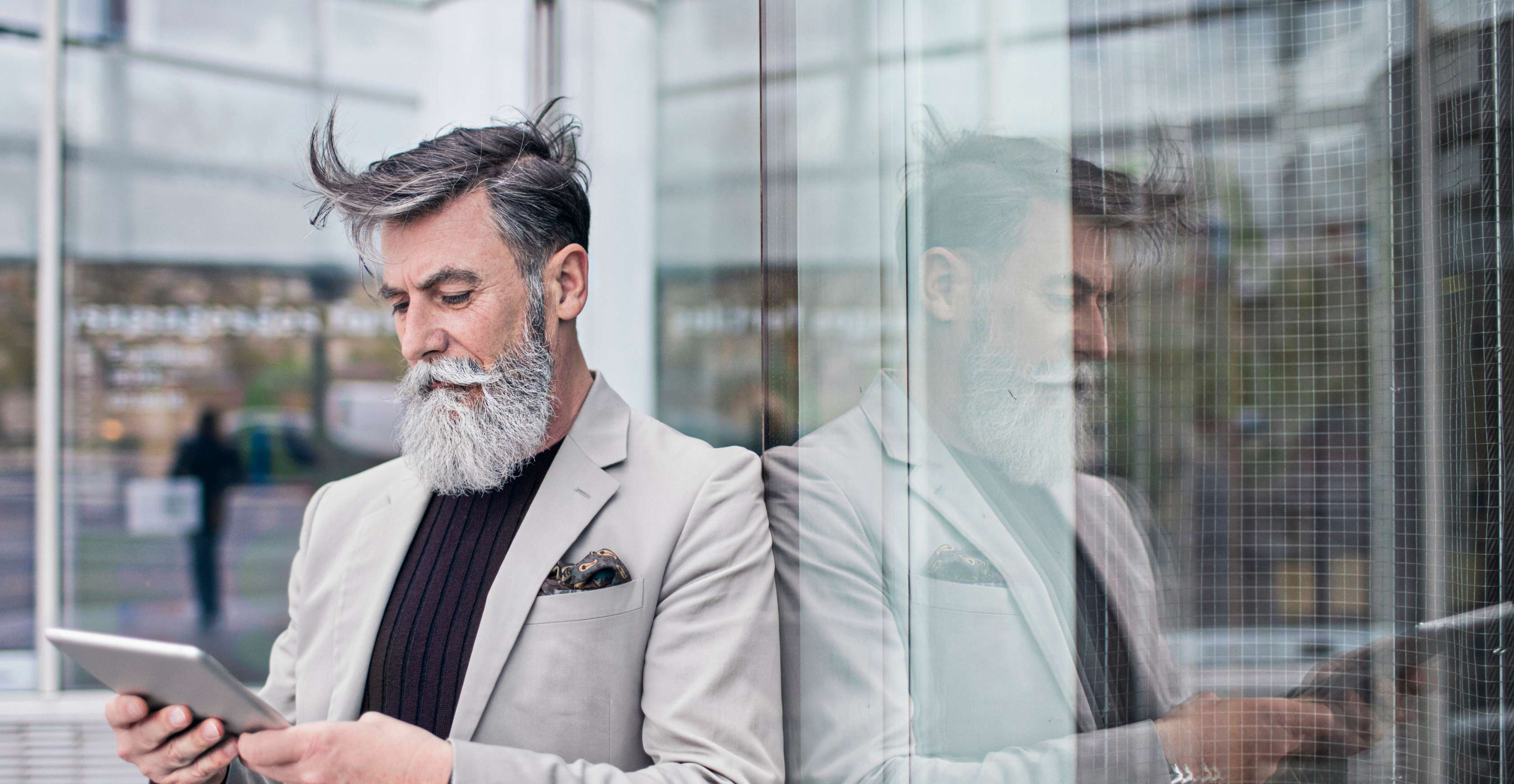 Allianz Zahlungsintervall Ihrer Versicherungsbeiträge ändern: Bärtiger Mann bearbeitet sein Zahlungsintervall auf Meine Allianz via Tablet.