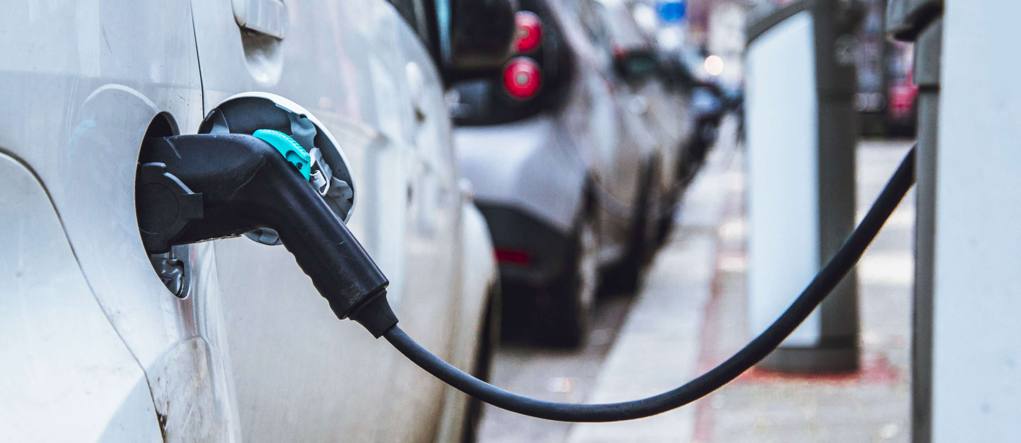 Allianz - Elektromobilität: Elektroauto ist an Wallbox angesteckt und lädt