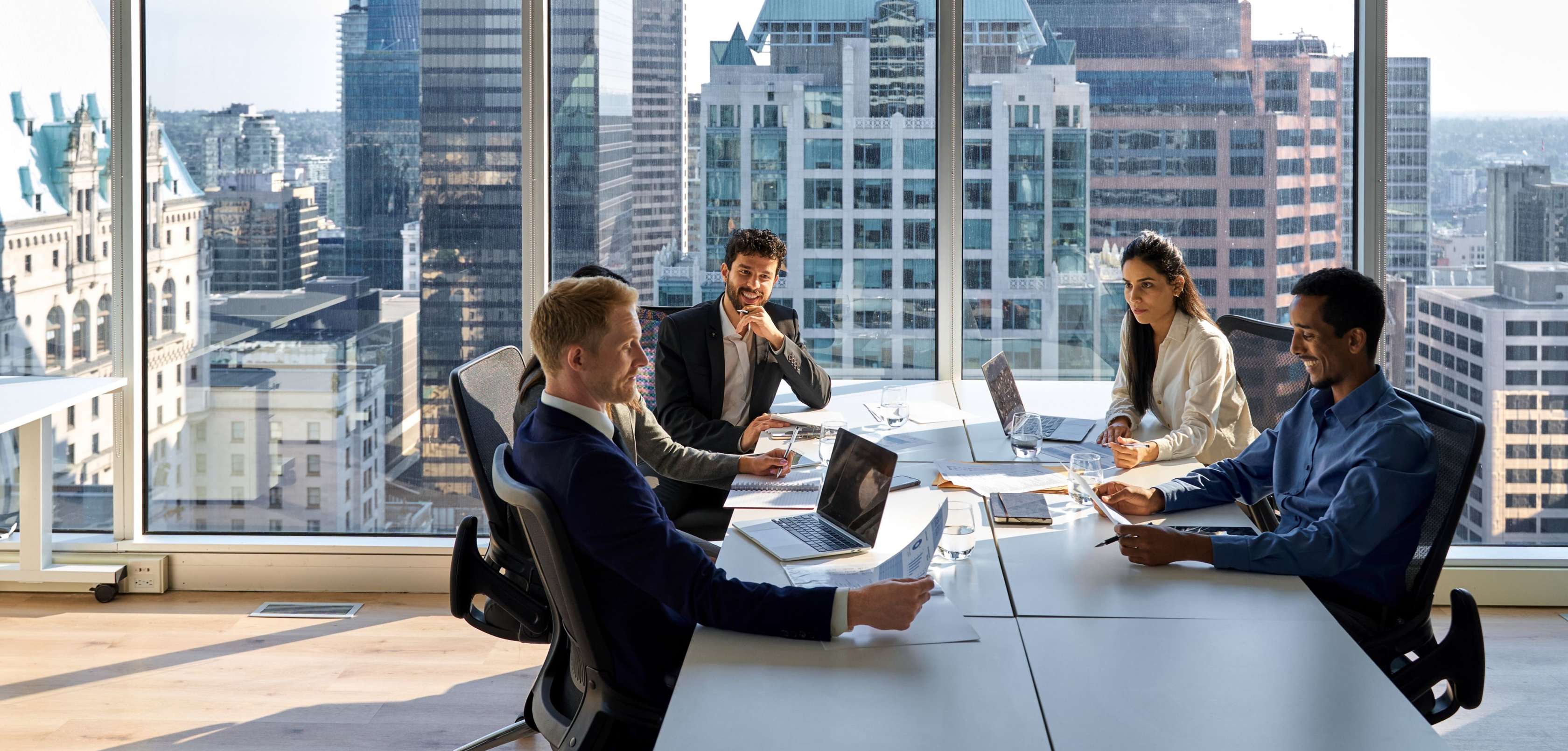 Versicherungen für Jungjuristen: fünf junge Frauen und Männer sitzen an einem Konferenztisch