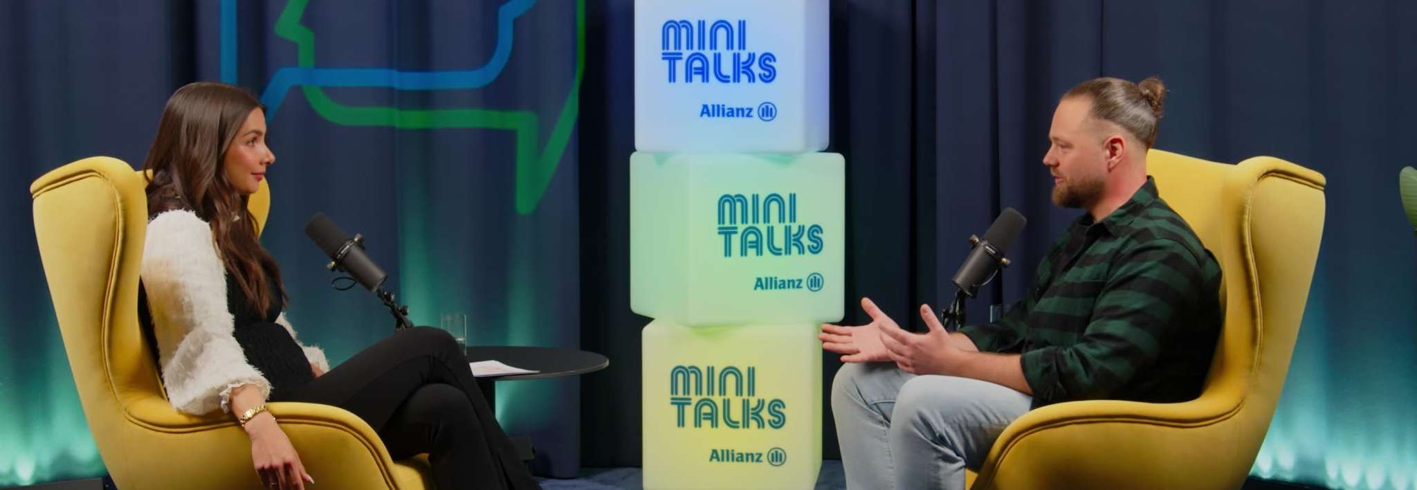 Allianz MiniTalks Folge 10 Berufsunfähigkeitsversicherung: Lea Wagner und Yannic sitzen im Studio auf zwei Sesseln.