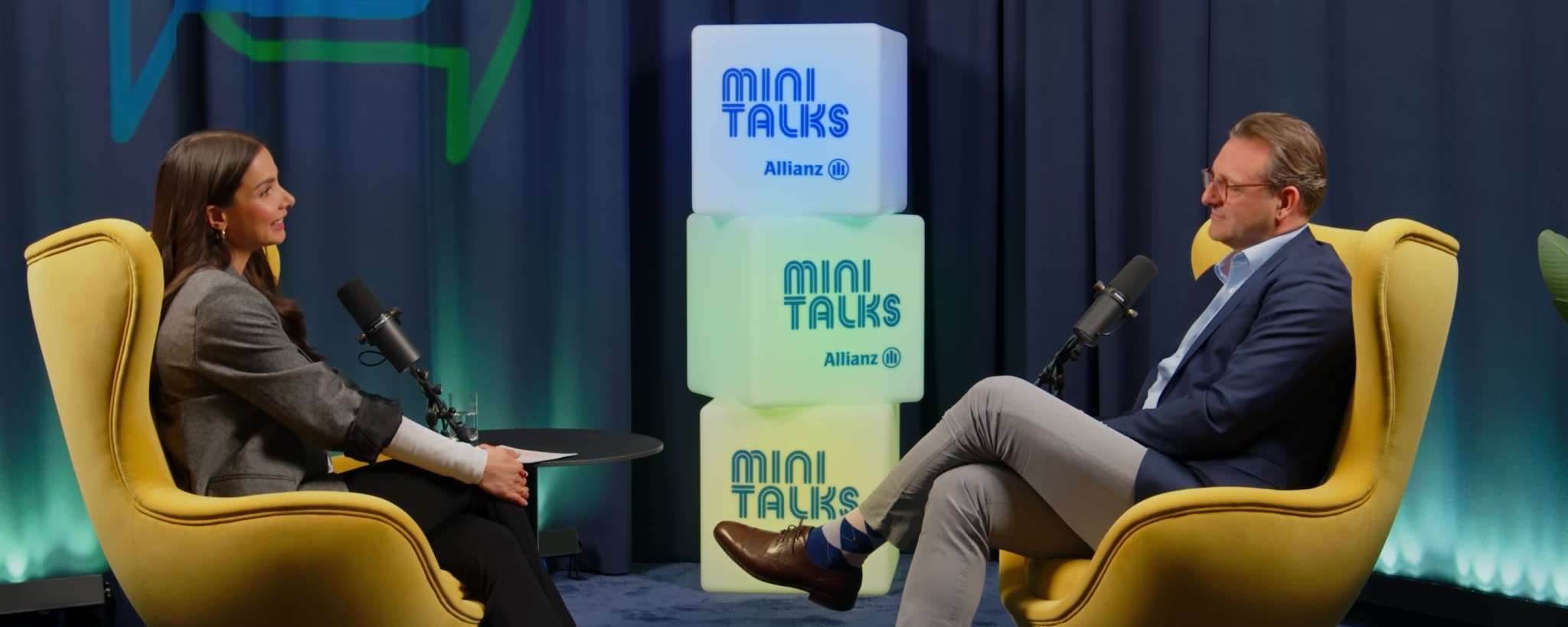 Allianz MiniTalks Folge 11 Erster Besuch beim Versicherungsvertreter: Lea Wagner und Björn sitzen im Studio auf zwei Sesseln.