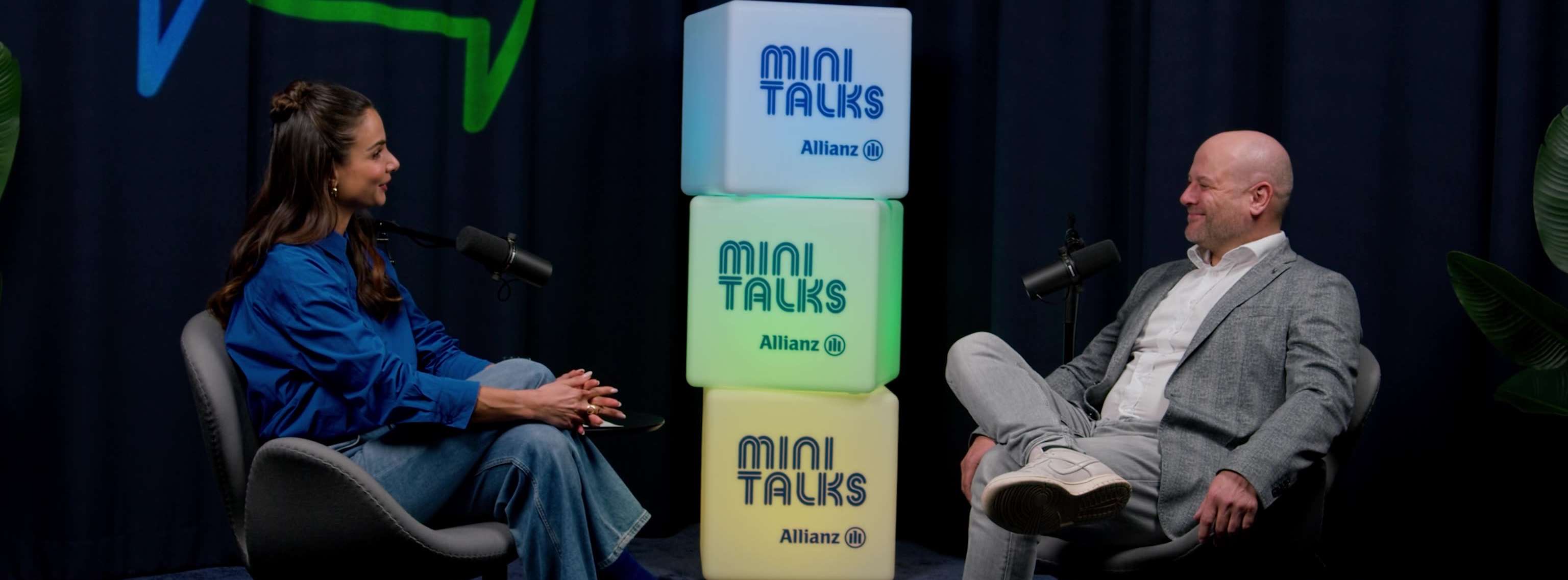 Allianz MiniTalks Folge 2 Vorsorge für Kinder: Lea Wagner und Denis sitzen im Studio auf zwei Sesseln.
