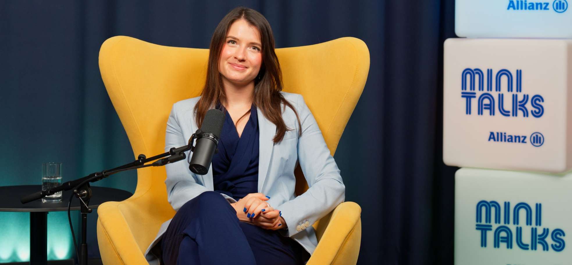Allianz MiniTalks Folge 20: Altersvorsorgedepot: Worauf kommt es bei der Anbieterwahl an?: Julia sitzt im Studio auf einem Sessel.
