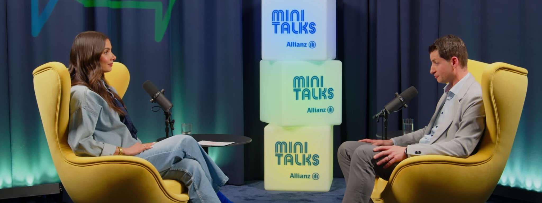 Allianz MiniTalks Folge 7 Meine Allianz: Lea Wagner und Georgios sitzen im Studio auf zwei Sesseln.