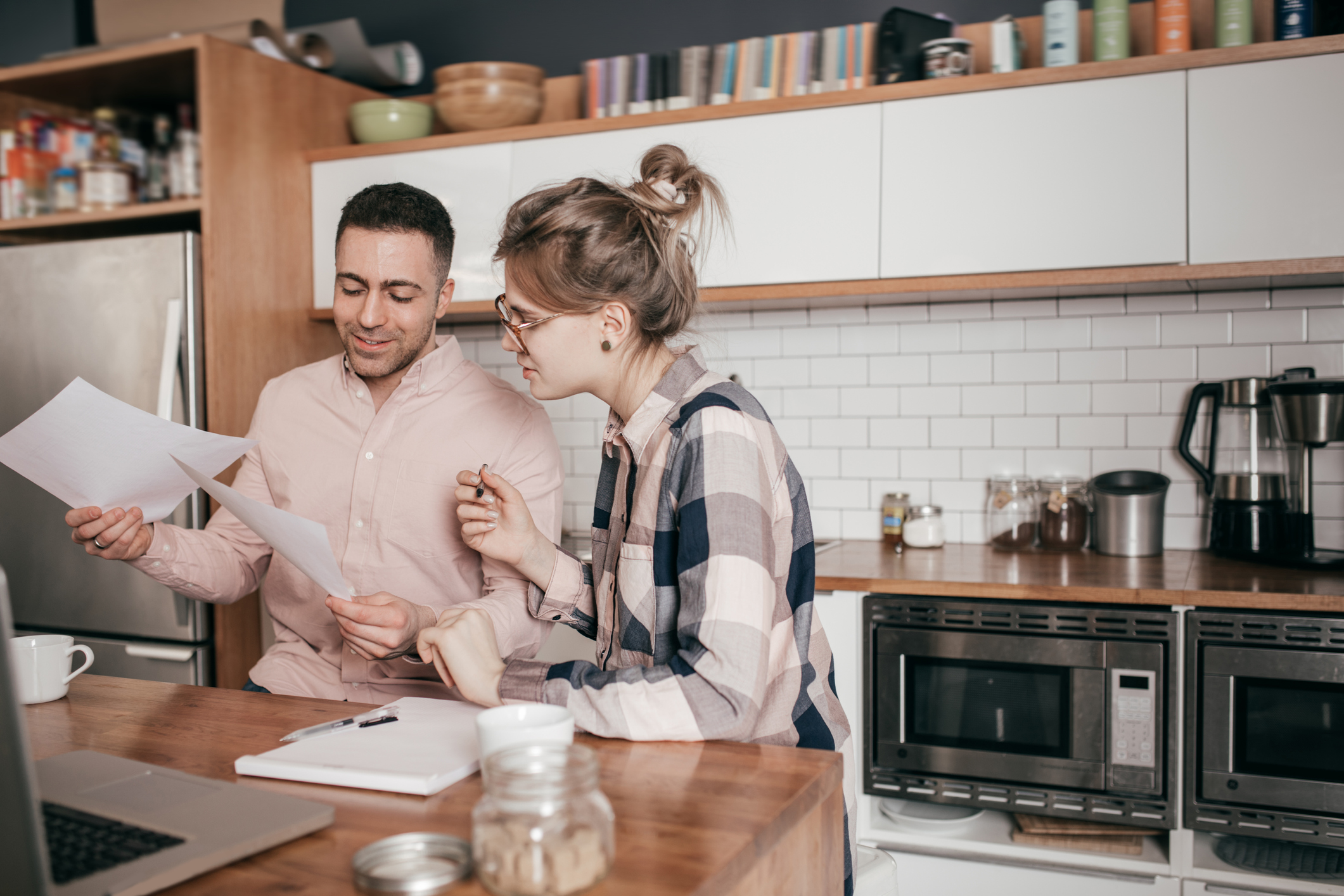 Allianz - Altersvorsorge - Alternativen: Mann und Frau stehen in der Küche und schauen sich Unterlagen an