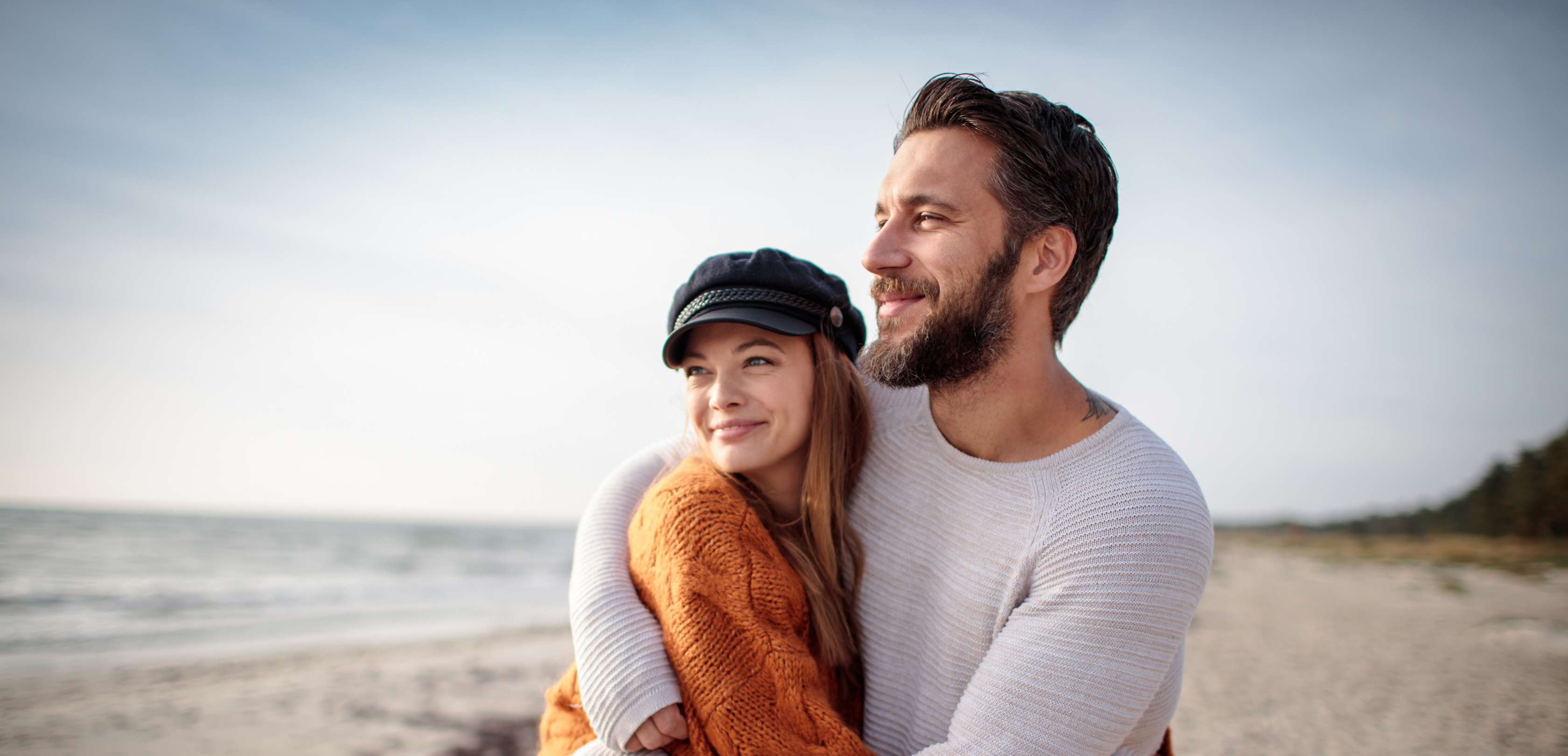 Allianz - Altersvorsorge - Alternativen: Mann und Frau stehen am Strand, schauen zum Horizont während sie sich umarmen
