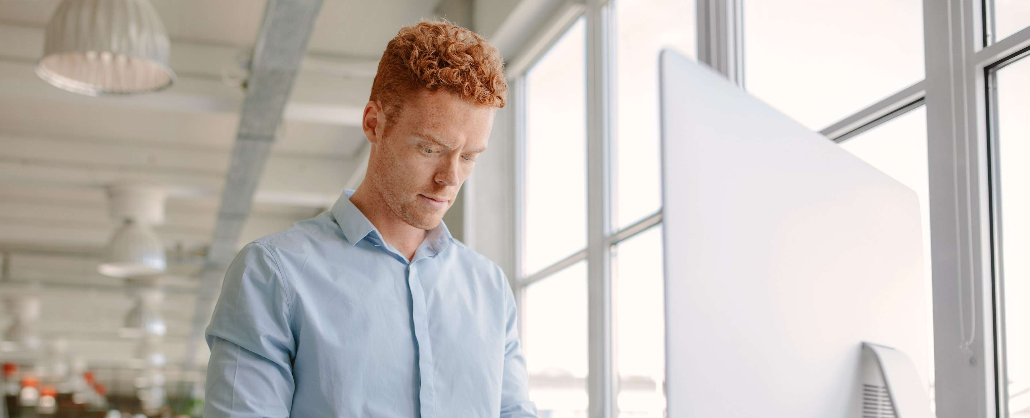 Arbeitskraftsicherung der Allianz - Ein Mann steht an seinem Computer und recherchiert. 