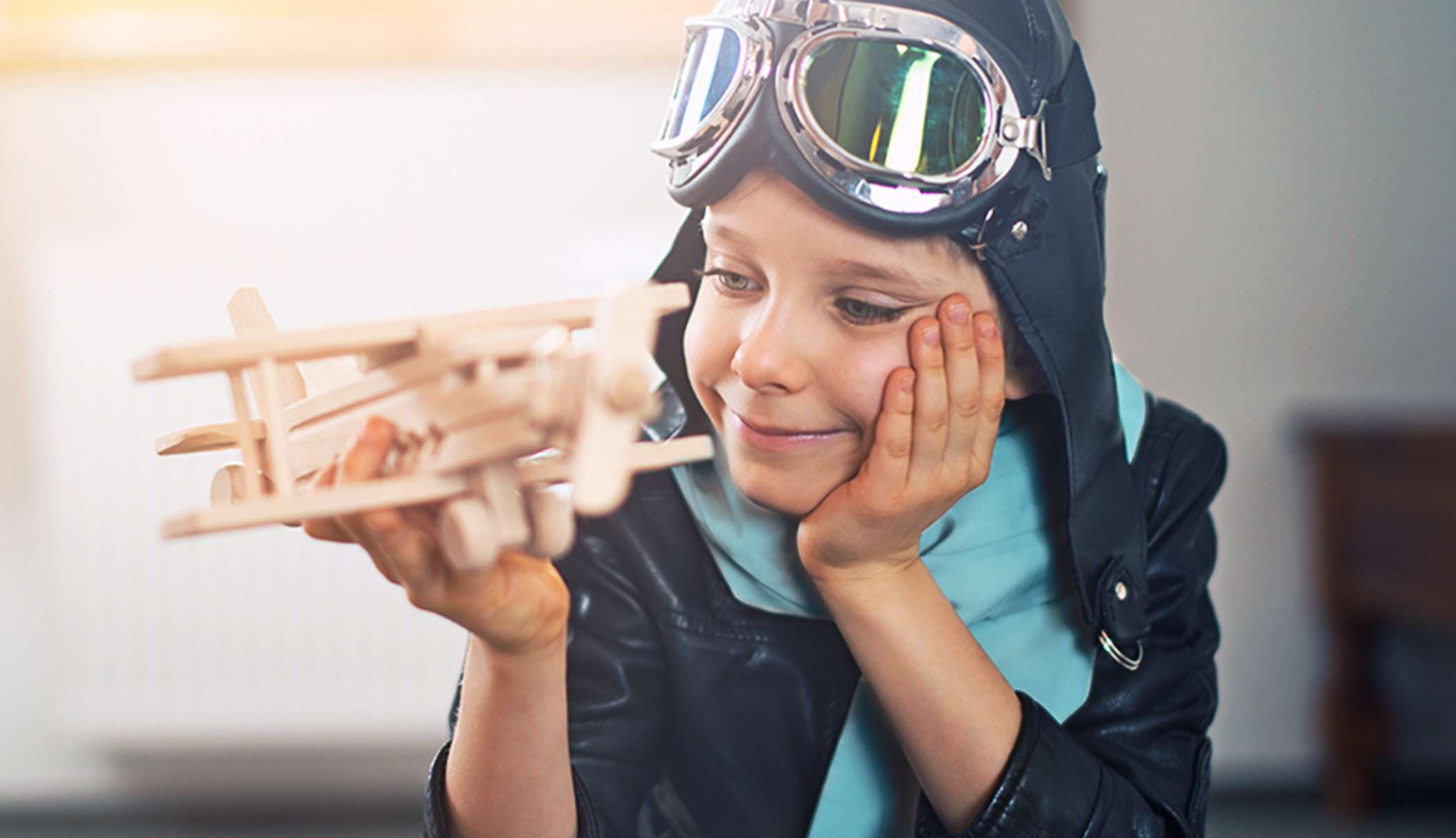 Allianz AusbildungsPolice: Junge spielt mit einem Holzflugzeug