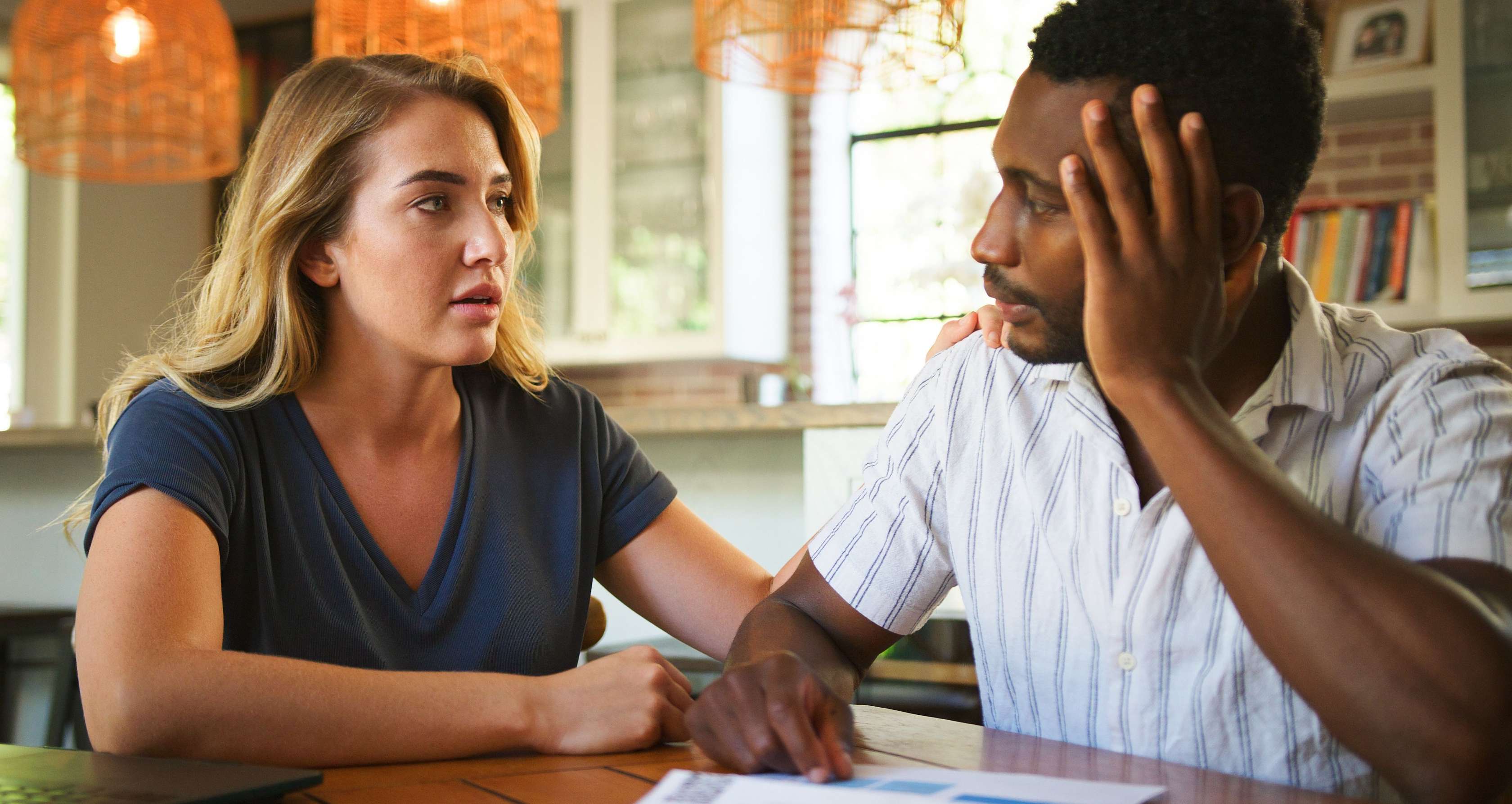 Allianz Berufsunfähigkeitsversicherung wegen Depressionen - Frau und Mann sitzen nachdenklich an einem Tisch.