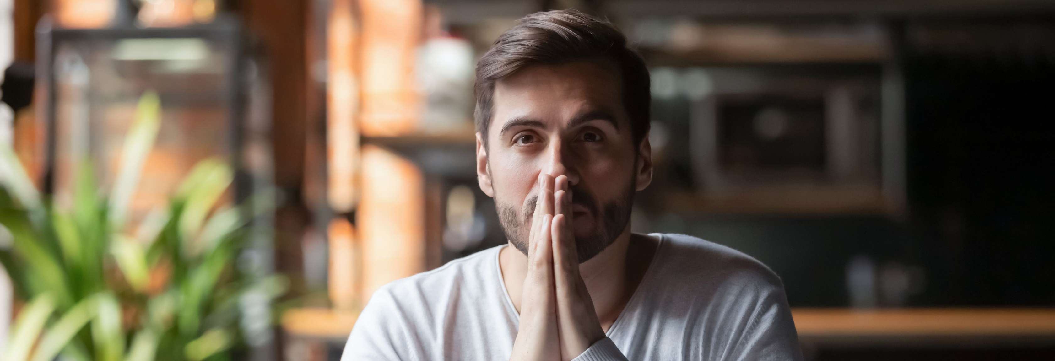 Allianz Erwerbs­unfähigkeits­versicherung – Für wen ist sie sinnvoll? Ein Mann sitzt nachdenklich vor seinem Laptop.