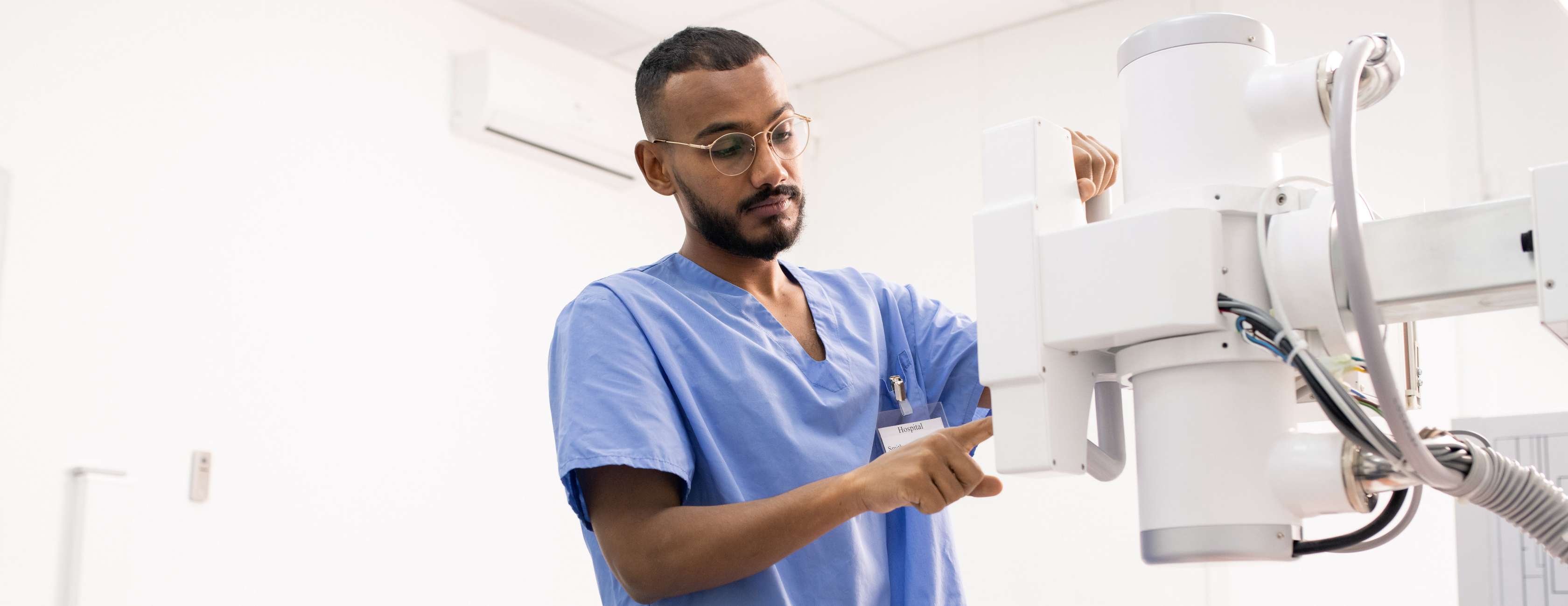 Krankenpfleger stellt ein Röntgengerät ein