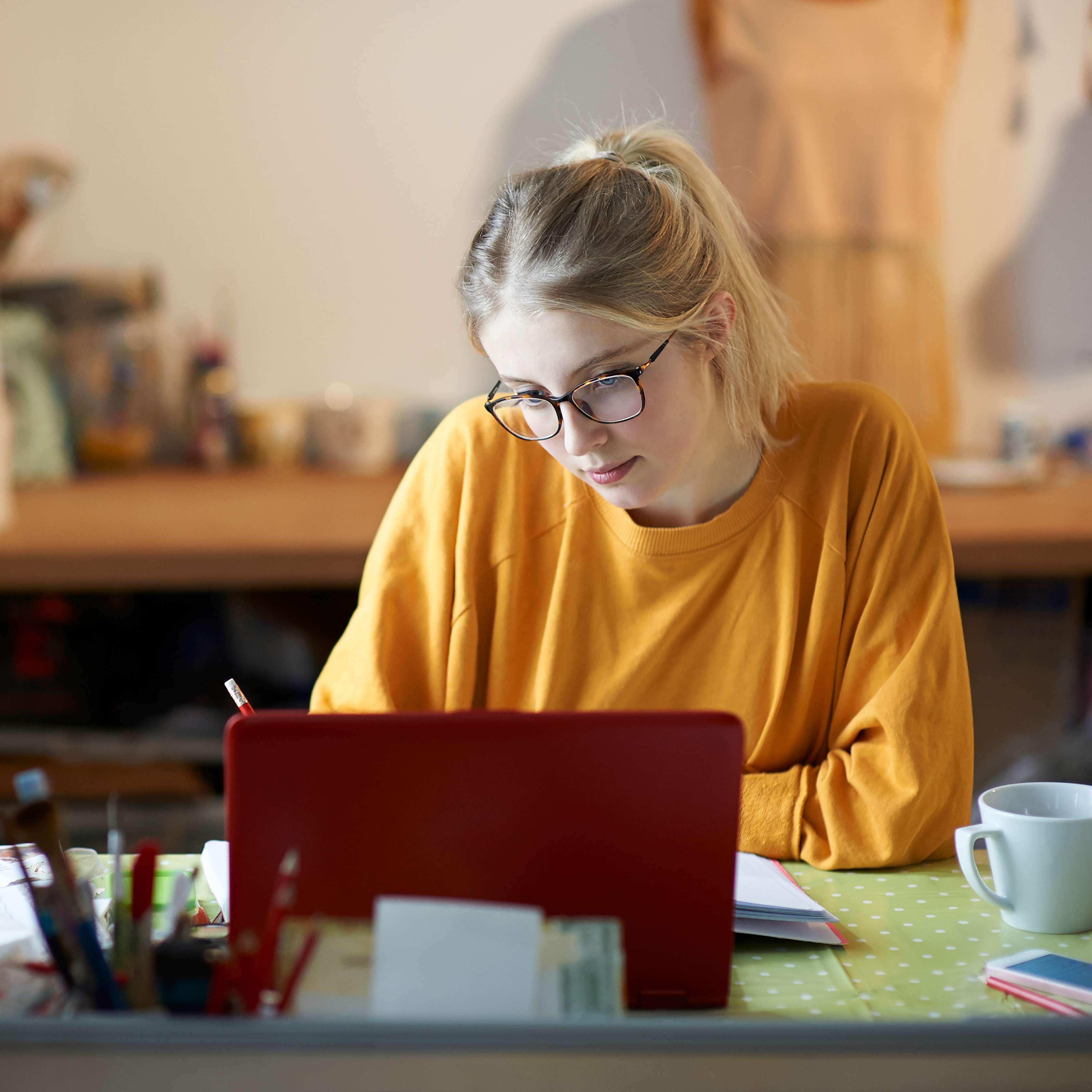 Allianz - Junge Frau arbeitet am Schreibtisch mit Laptop